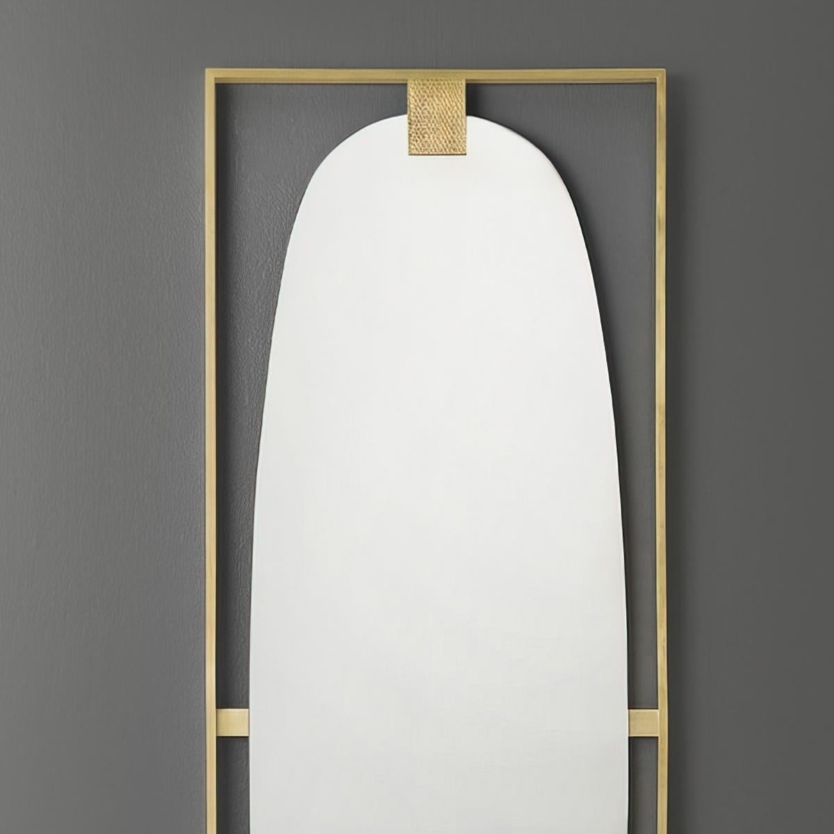 Art Deco Brass Wall Mirror, a tall rectangular form wall mirror with a polished satin brass frame centered with an oval mirror plate.

Dimensions: 19.5