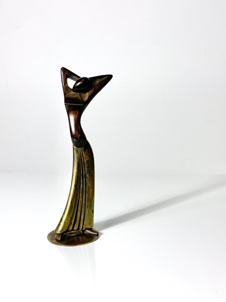 Art Deco figurative sculpture by Hagenauer Werkstatte Wien Austria 
Circa 1930s
Sculpted wood and brass silhouette of a female mounted to brass base
Signed to underside

3.5 inch diameter
9 inch height


