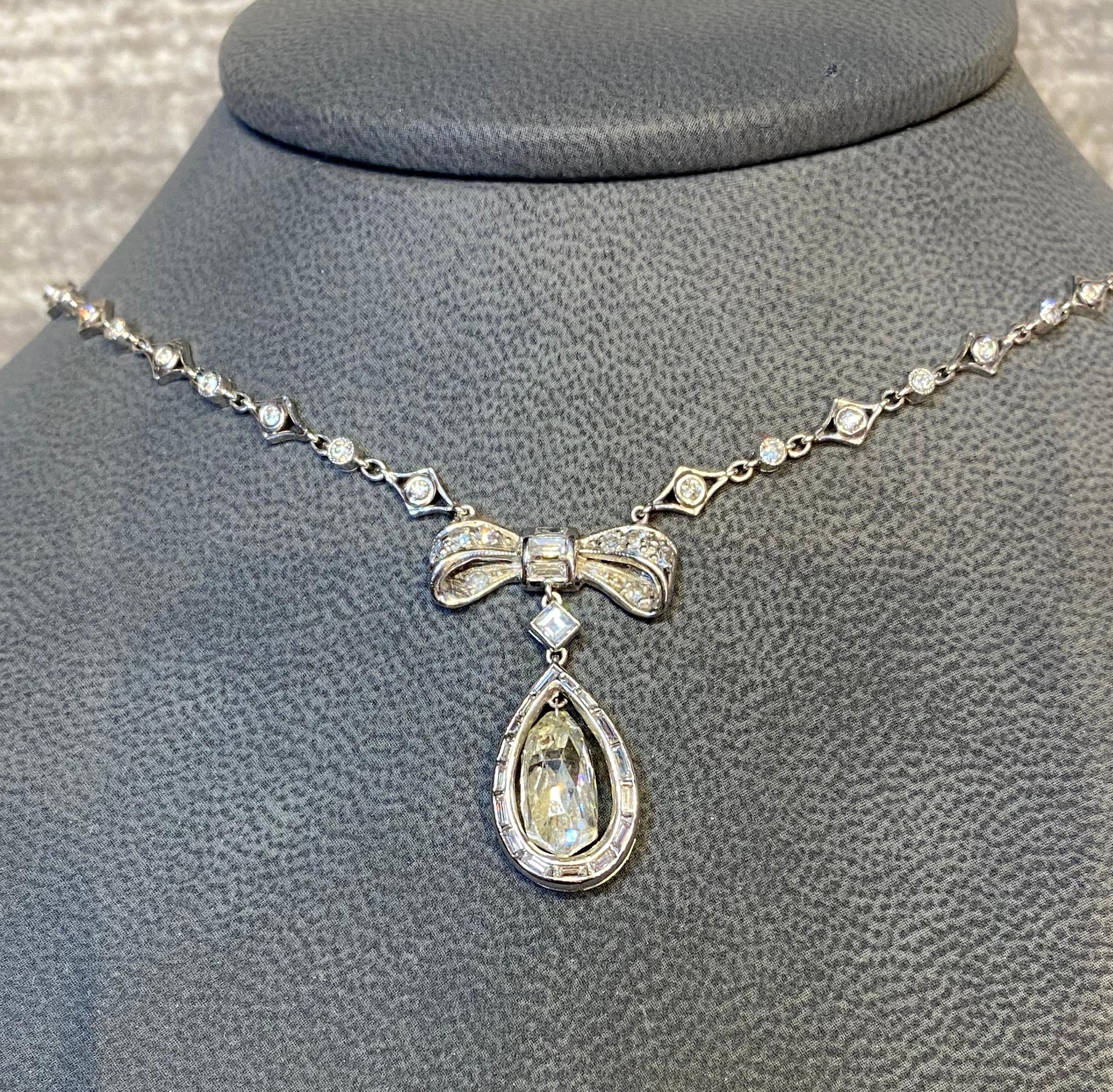 Art Deco Briolette cut Diamond Bow Necklace

Approximately 7 ct briolette diamond bead on platinum diamond link chain.
Approximately 2.58 ct s of round cut diamonds 
Approximately 1.10 cts of baguettes & diamond shape diamonds
Chain Measurements: