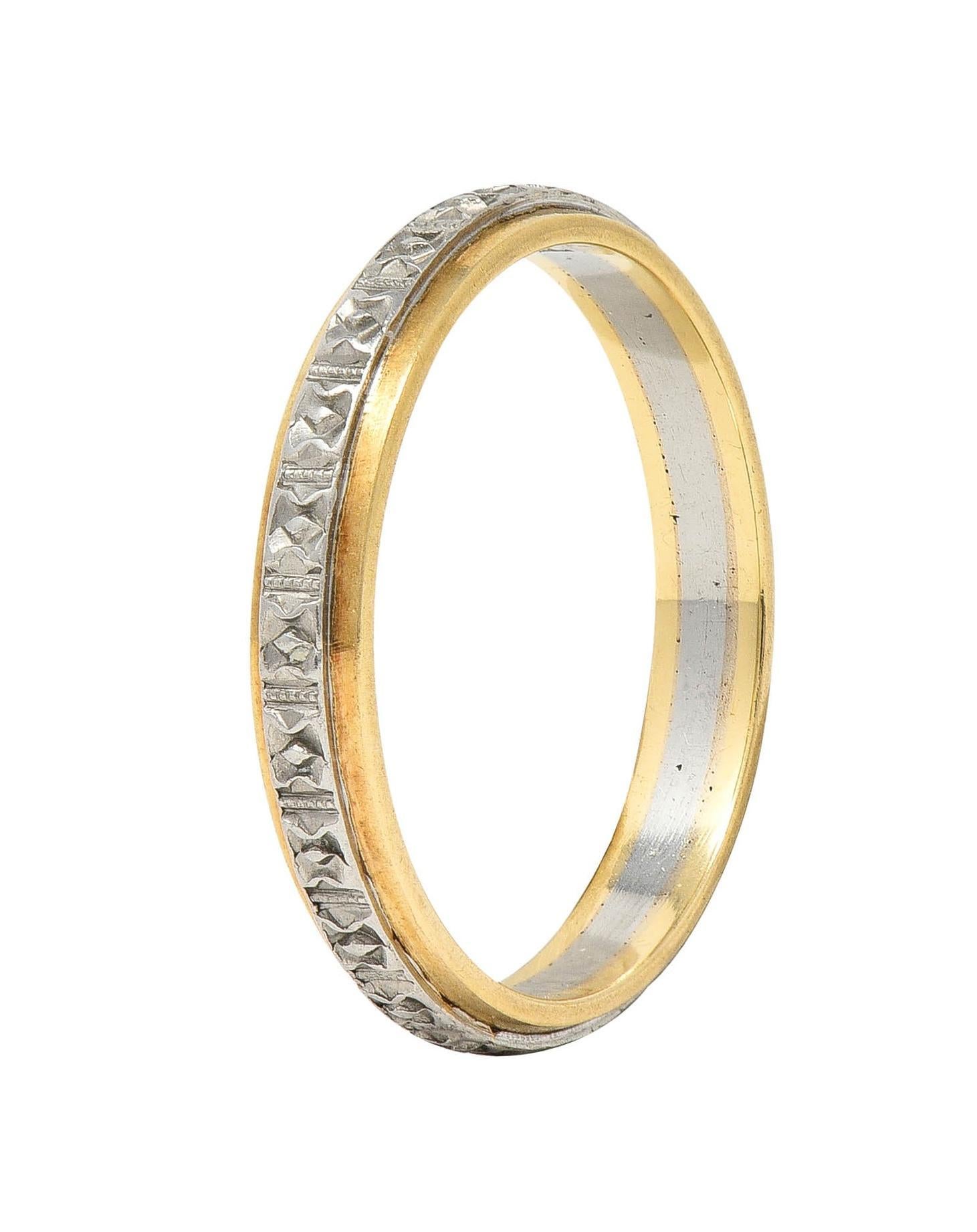 Designed as a raised platinum band with a grooved orange blossom motif fully around 
Centered on a yellow-gold recessed band
With milgrain detail 
Stamped for platinum and 14 karat gold
With maker's mark for Bristol Ring Co.
Circa: 1930s
Ring size: