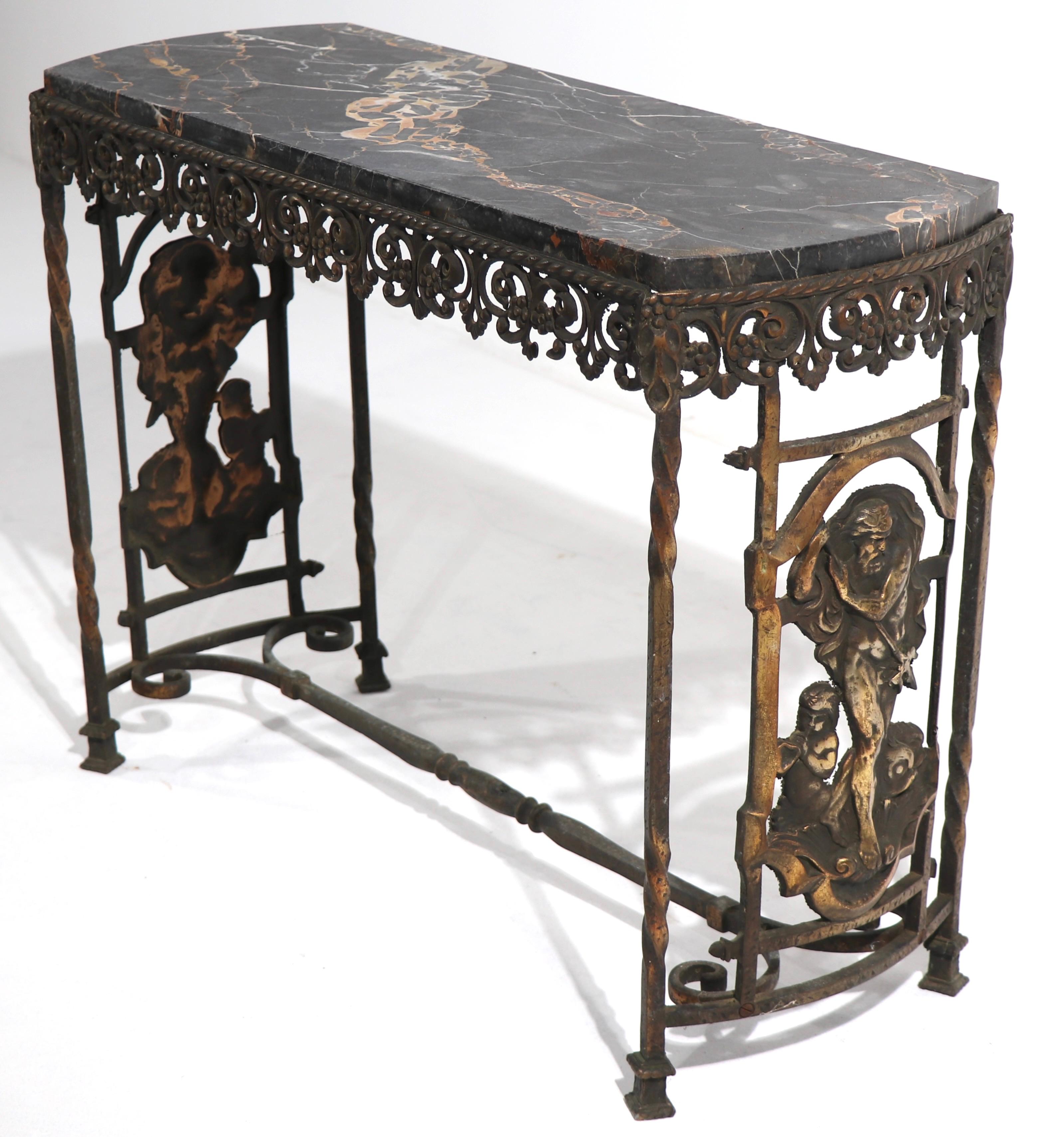 Art Deco period table having a cast bronze base and original oval marble top.
The base features decorative cast panels depicting classical imagery, the squared legs twist and the top metal skirt is reticulated. Heavy, well cast, and in very good