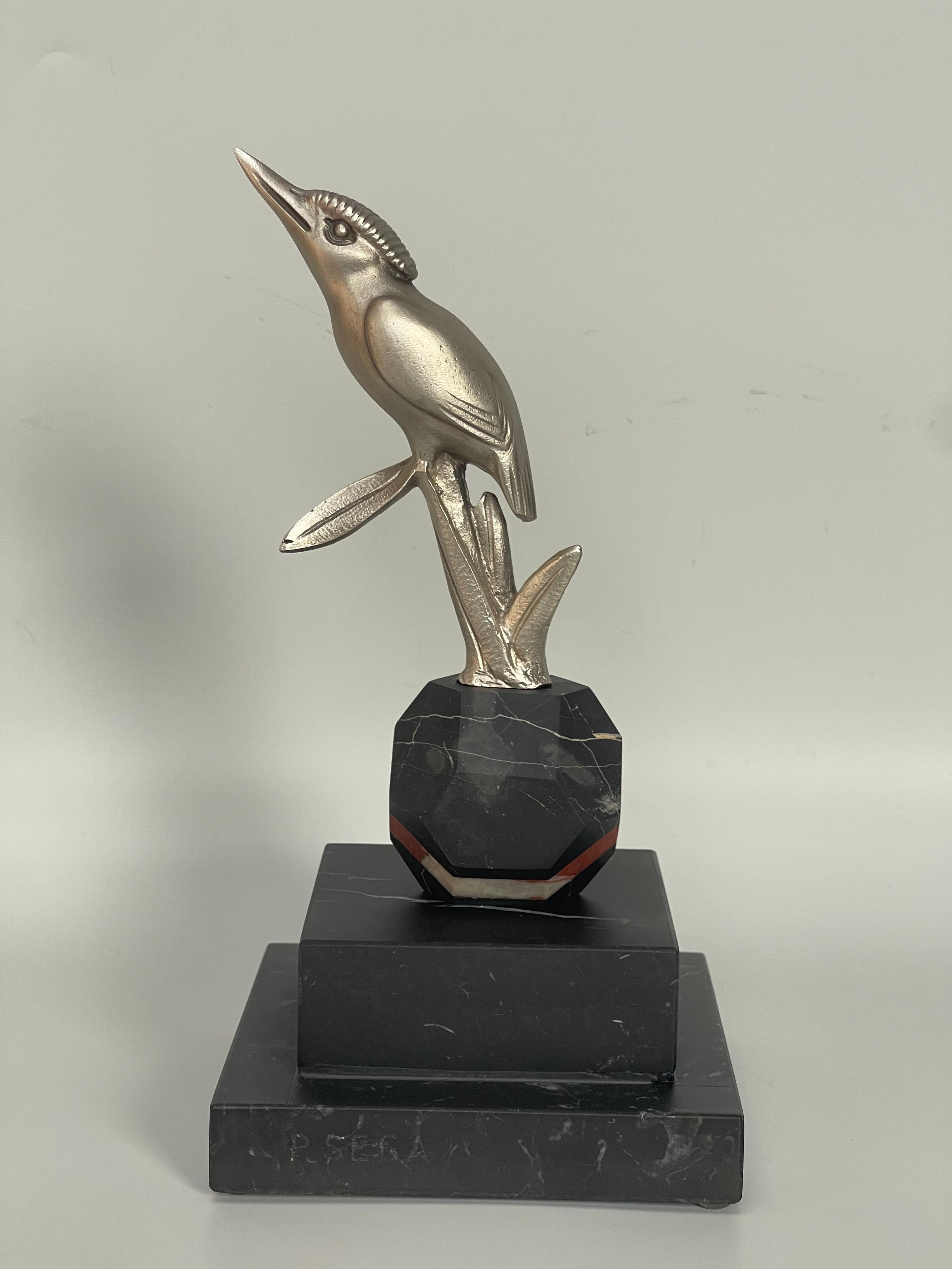 Art deco paperweight circa 1930.
Kingfisher in silvered bronze on a black marble base veined with white.
Signature on the base P. Sega for Pierre Sega.
In perfect condition.

Height: 21.5cm
Width: 11cm
Depth: 11cm
Weight: 1.7 kg

PIERRE SEGA: late