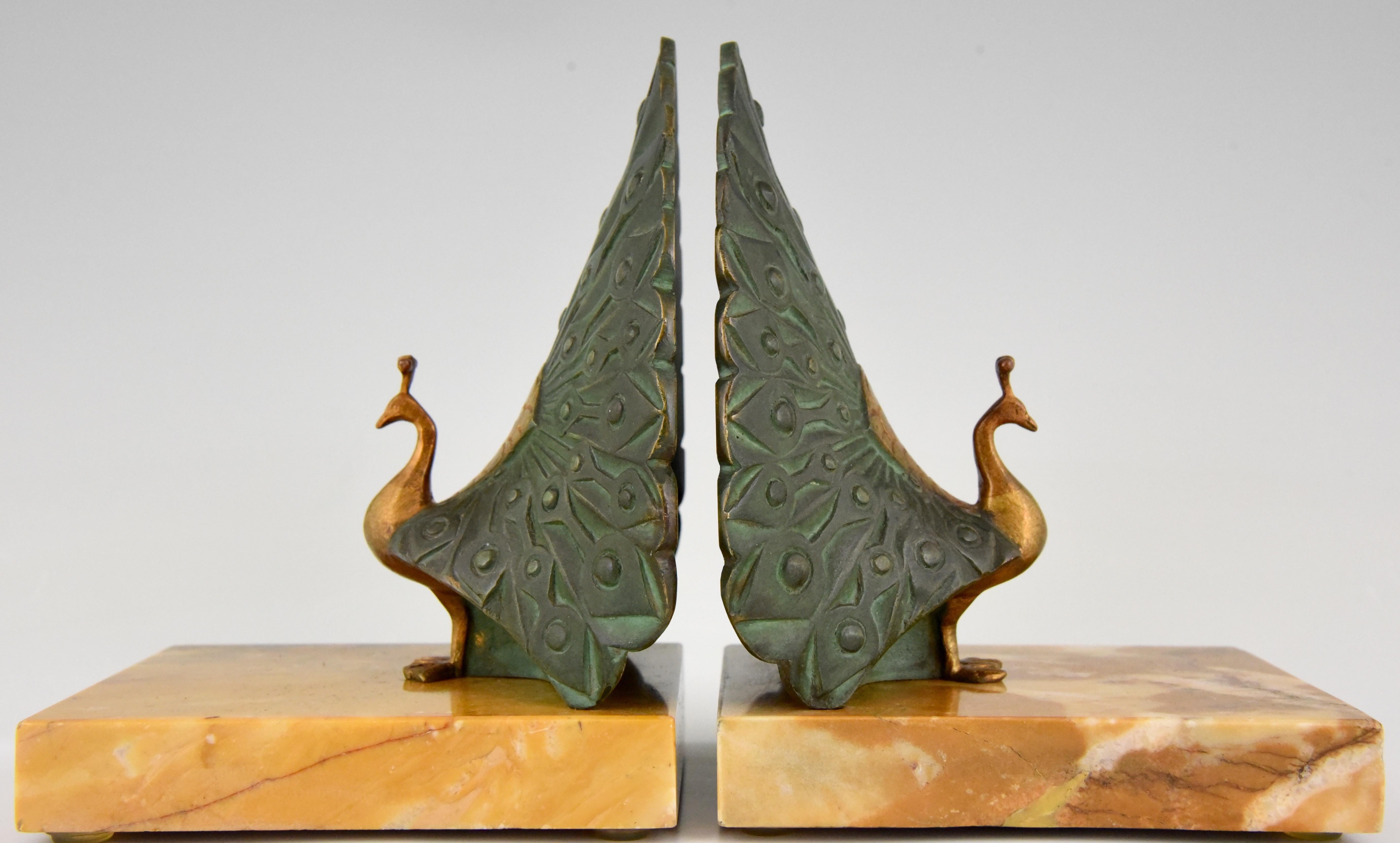 Stylish pair of Art Deco bookends modelled as peacocks. The bronze sculptures have a multi-color patina and stand on a yellow marble base. They are signed by the French artist Morante and created in 1925.
 