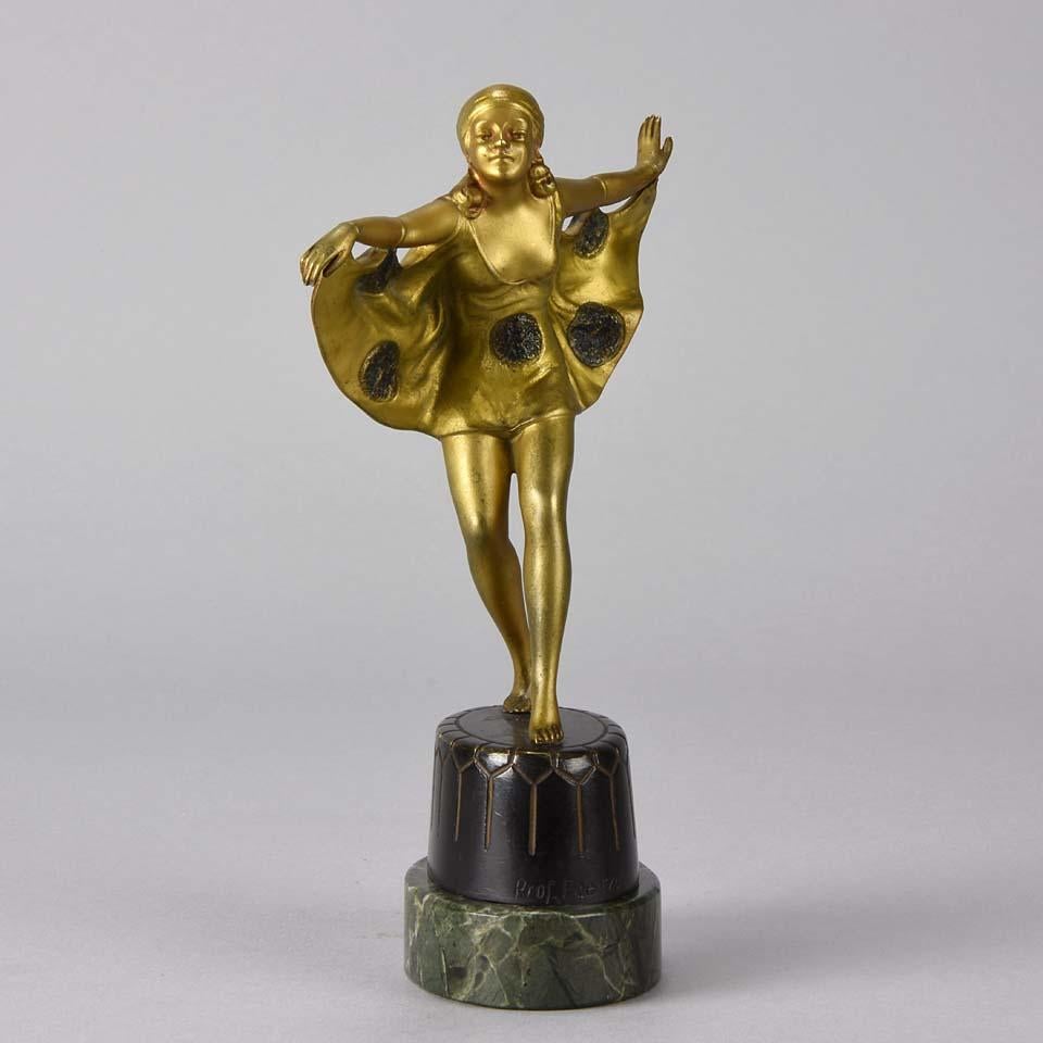 A fabulous early 20th century Art Deco cold painted bronze figure of a beautiful and elegant Art Deco dancer in striking stretched pose wearing a loosely hanging ‘winged’ costume. This fine sculpture has excellent detail and rich color heightened