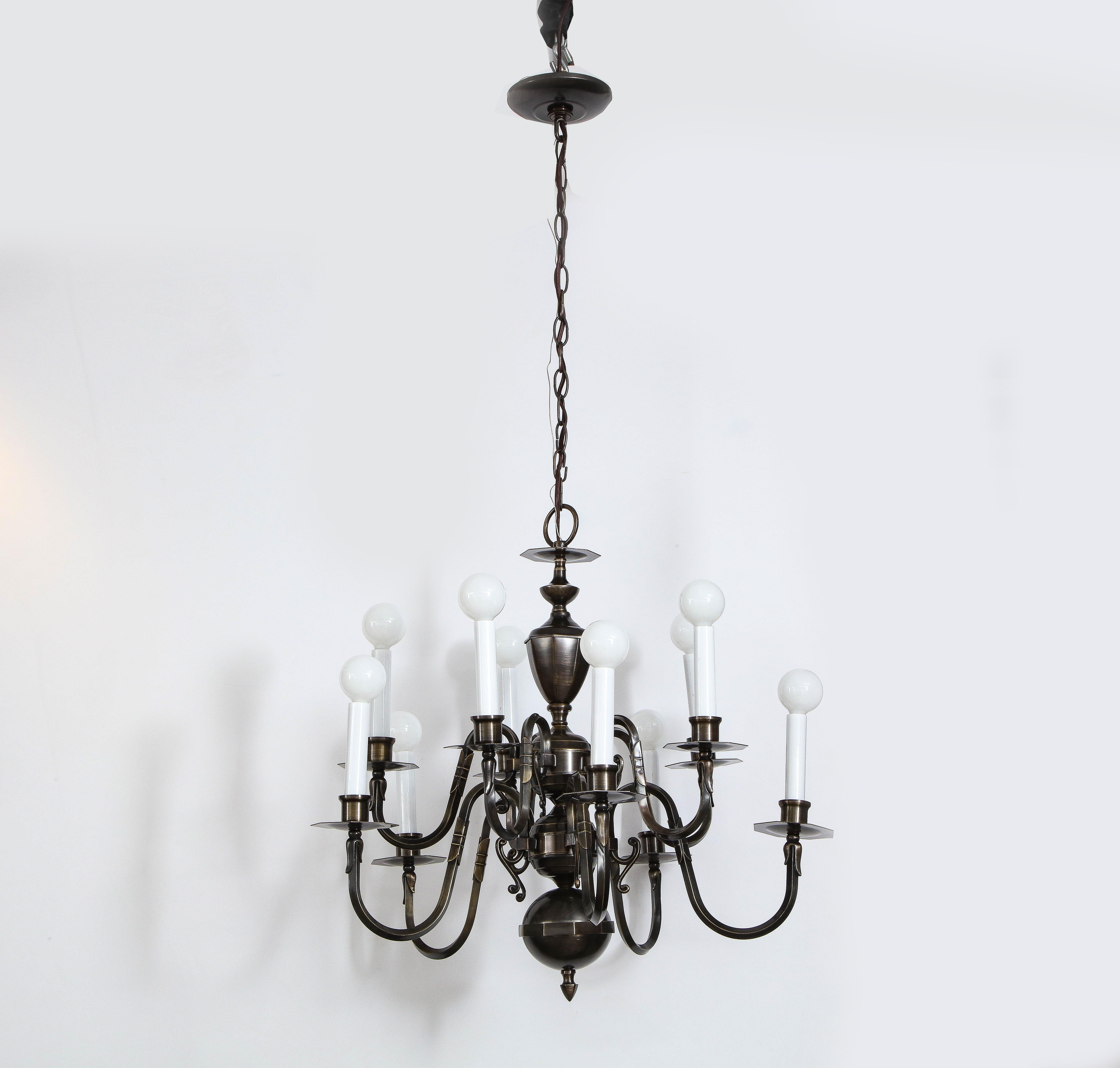 American Art Deco 12 arm hand forged dark bronze chandelier. 3 segemented faceted sphere segments compose the body and 12 graceful arms extend outwards. Rewired for use in the USA, shown here with globe chandelier bulbs.

As shown 42 inches in