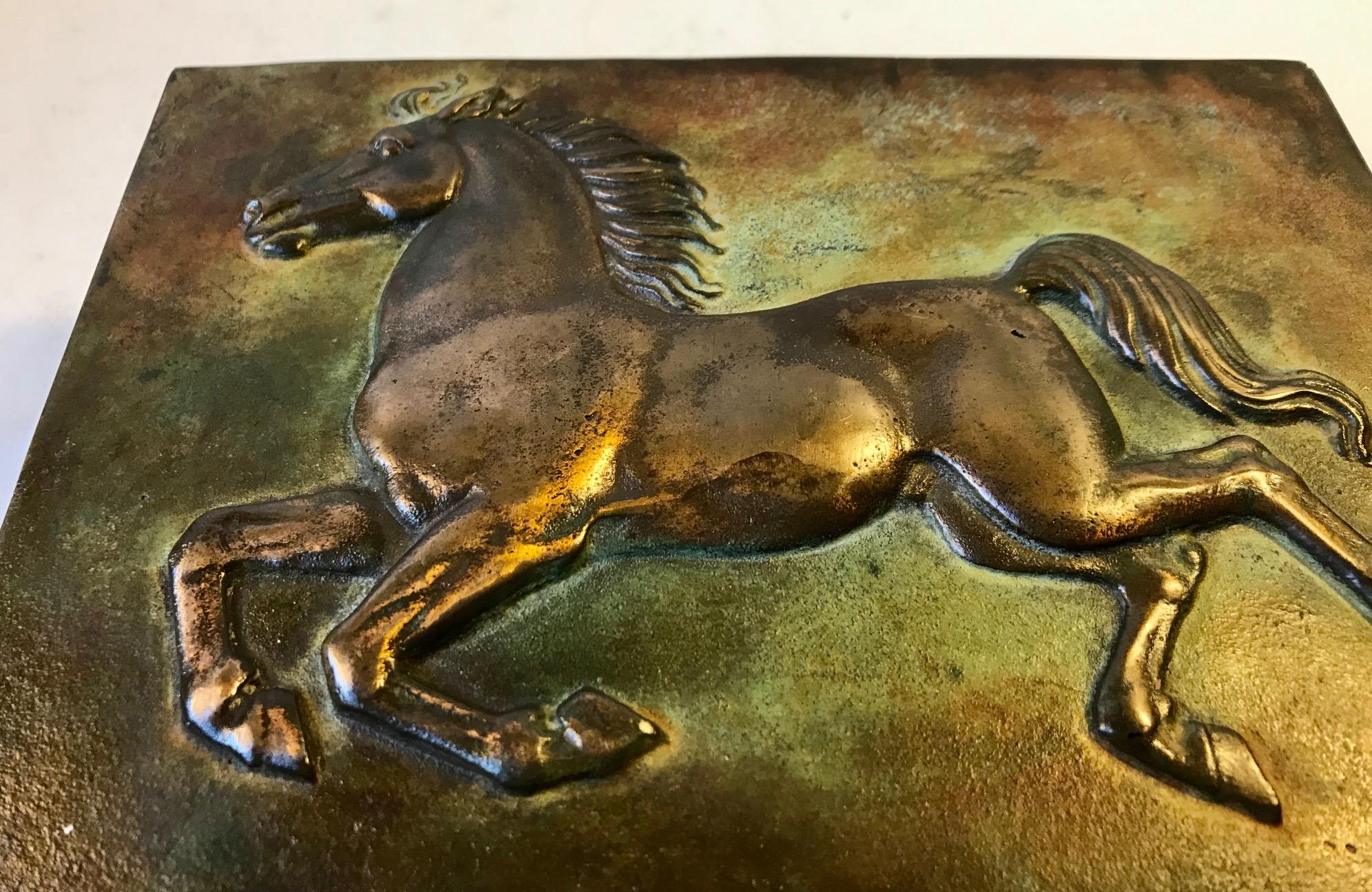 - Heavy Art Deco bronze box with stallion in relief. 
- Strict architectural framing and design. 
- Green, rich and original patina 
- It was manufactured in Denmark during the 1930s 
- Probably by either Tinos or Krone Bronce in Copenhagen
-