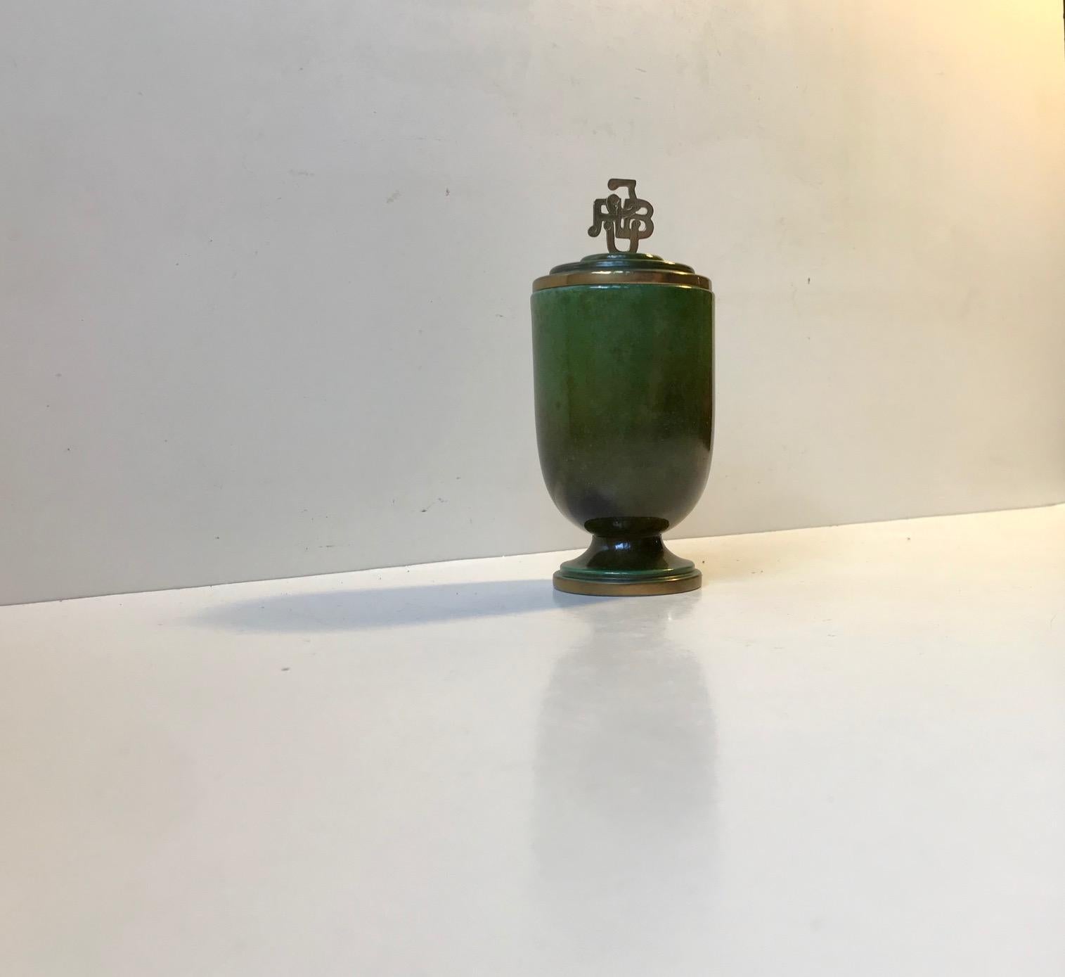Originally presented as a trophy to an amateur boxer in 1949 this green verdigris patinated jug is actually a cigarette holder/dispenser. It can contain in excess of 20 filter cigarettes. It has the emblem of JYSK amatør bokse union (The amateur