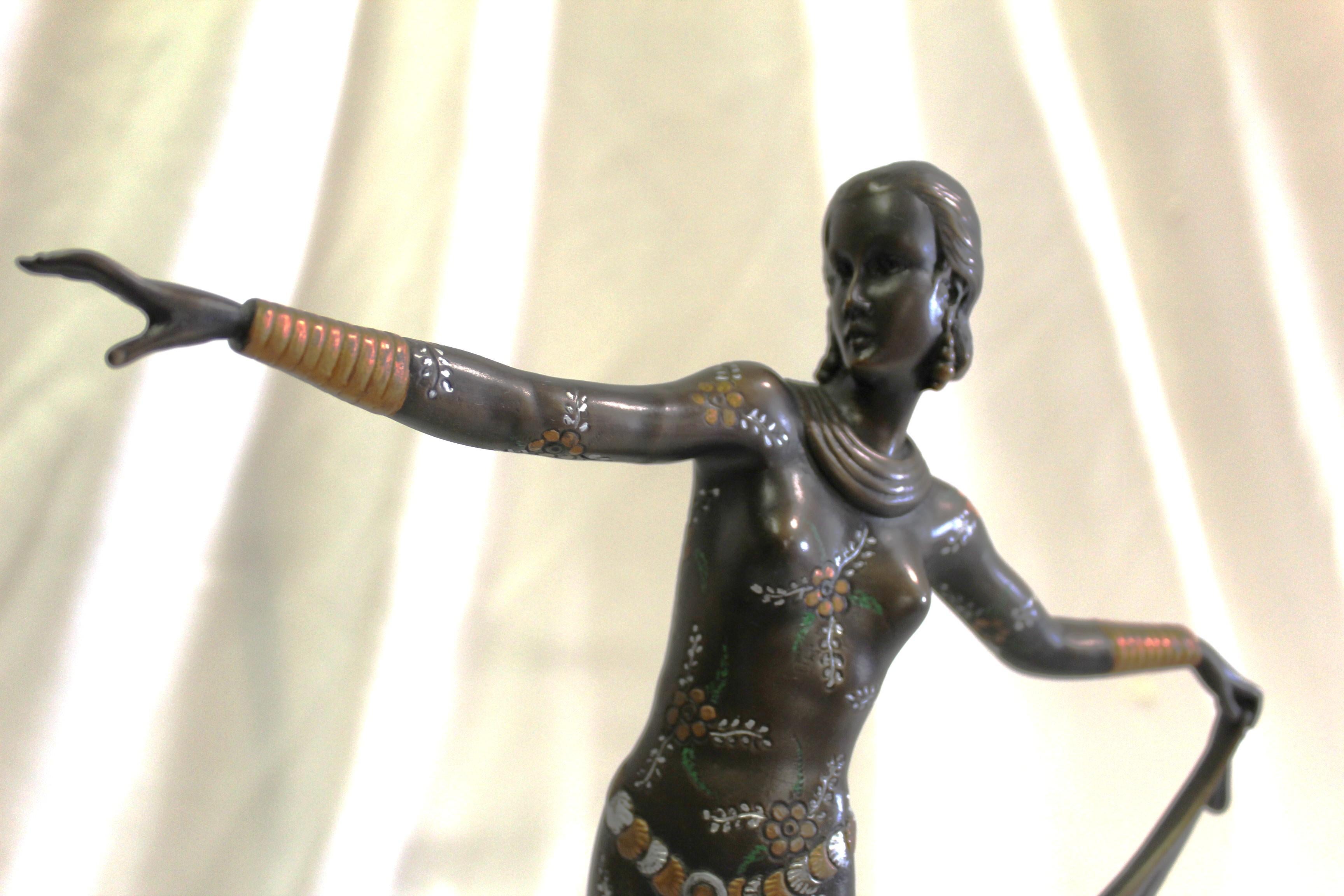 A Mid-Century /deco style Bronze Casting of a deco dancer holding her skirt up in hi-details with hand finished . She is standing on an Oval stone base also from England . There is artist marked on the oval metal base . see the details in the photos