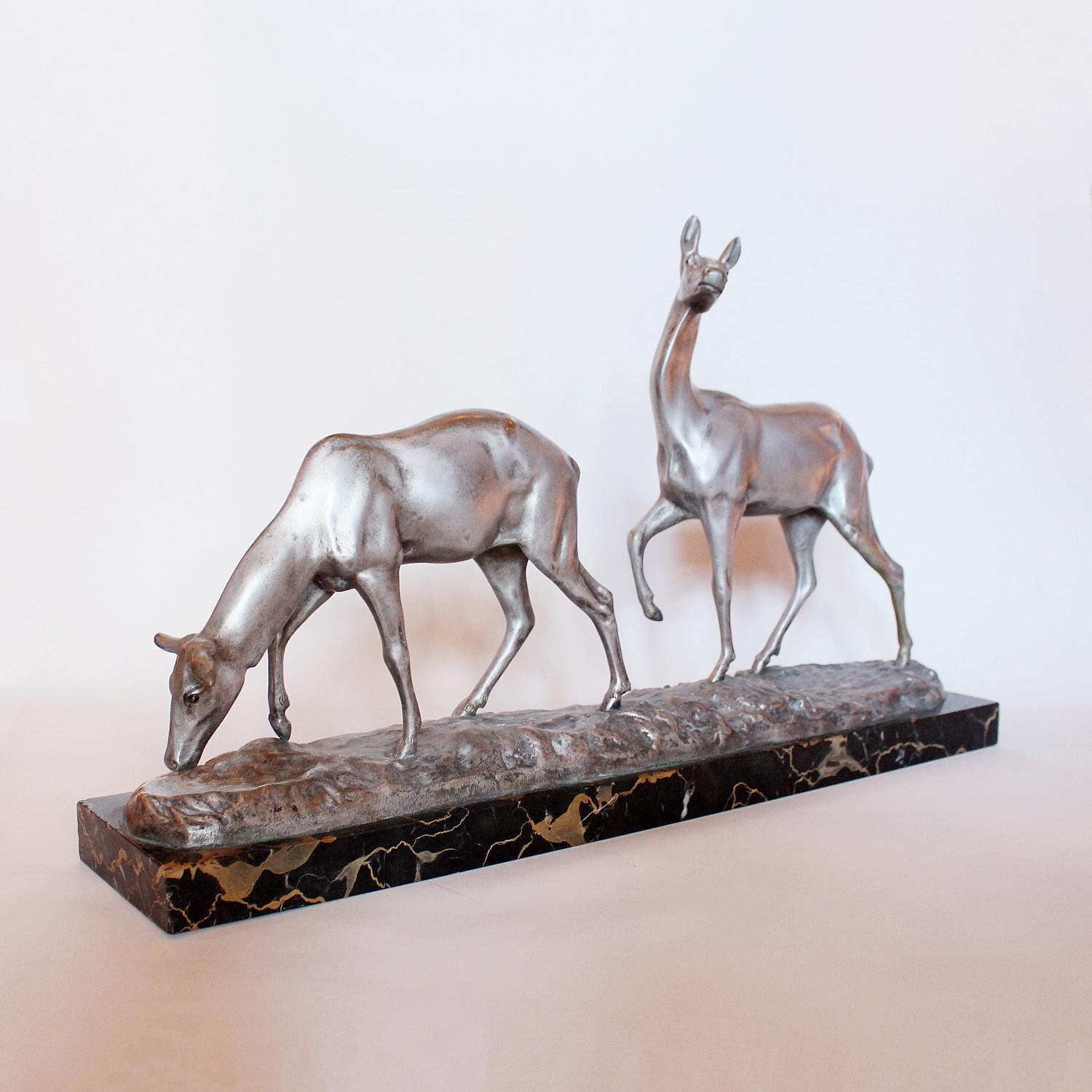 A silvered bronze group of a pair of grazing deer set over a naturalist base on a marble plinth.
Signed I Rochard to cast.





       