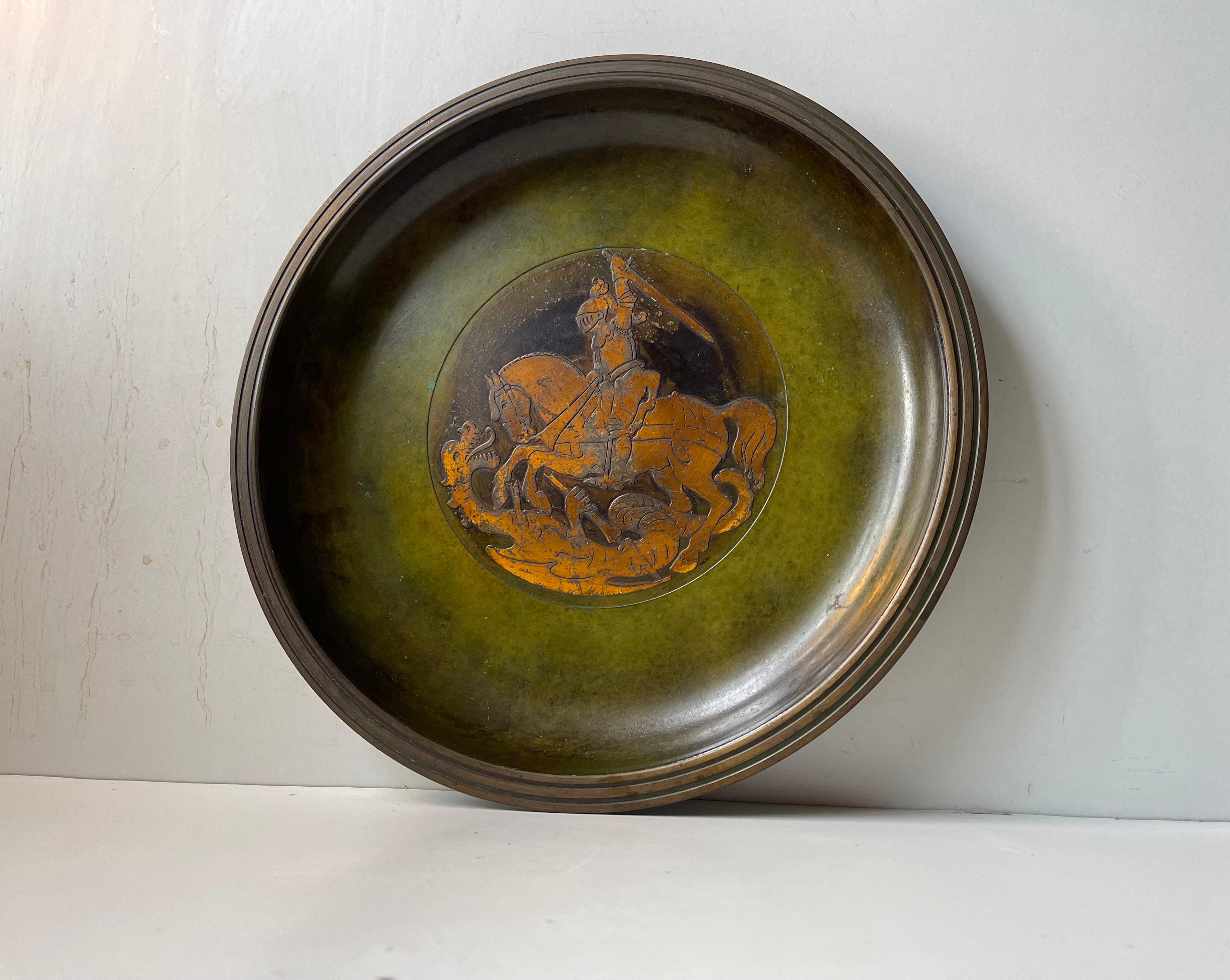Ciotola o caricatore in bronzo a rilievo con patina verde verdastra applicata (vernice a freddo). Progettato e prodotto da Holger Fridericias in Danimarca negli anni '20 o '30 in uno stile che ricorda Just Andersen. Il motivo - l'uccisore di draghi