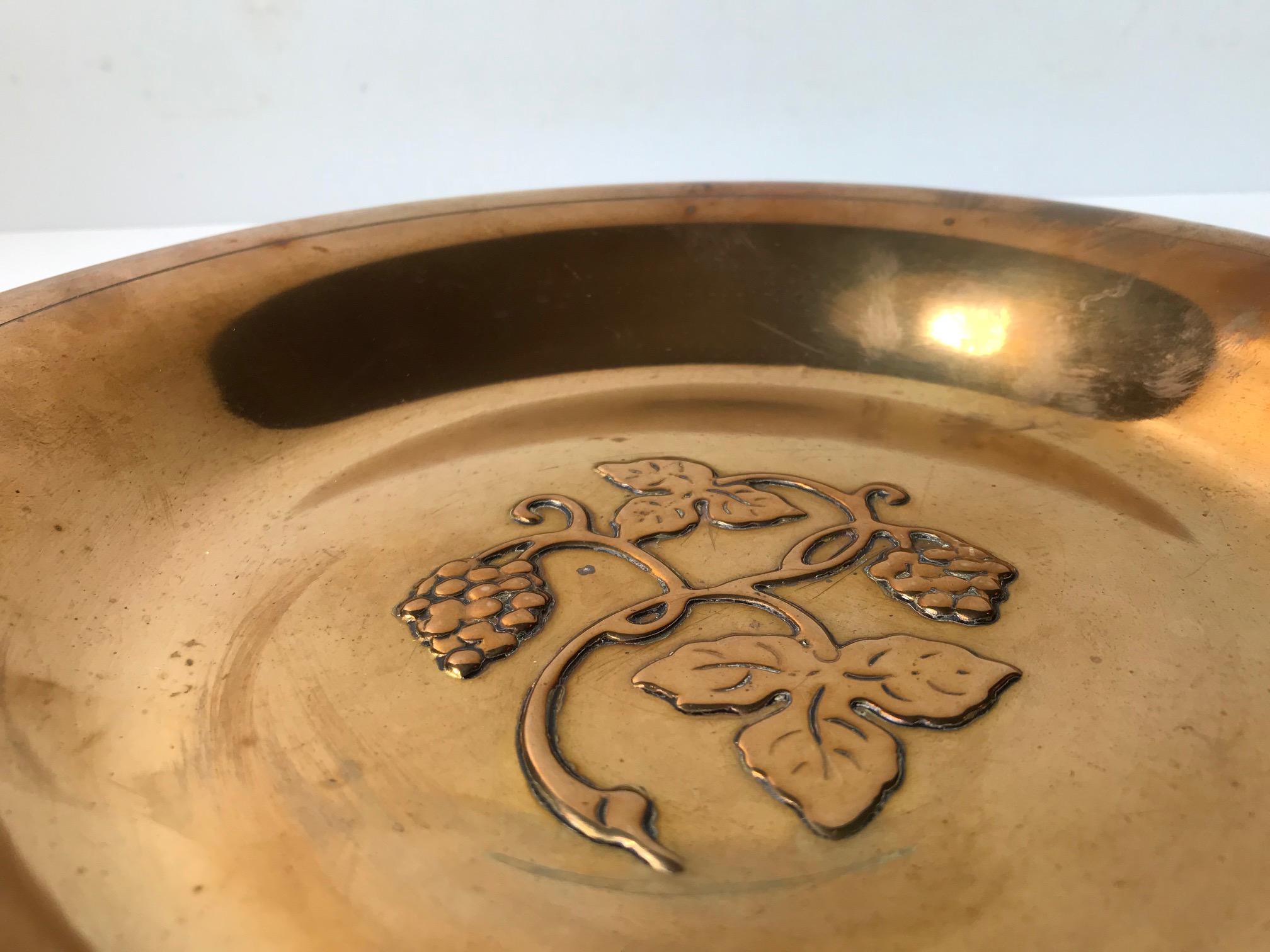 Un piatto o una ciotola in bronzo lucido decorato con un motivo a rilievo di uva. Progettata e prodotta da Ægte Ildfast Bronce in Danimarca negli anni '30 in uno stile che ricorda Just Andersen. Il piatto presenta un marchio di fabbrica sotto la