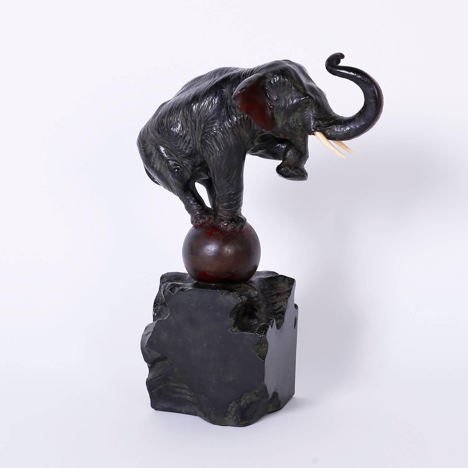 Art deco bronze elephant sculpture or object of art retaining its original patina, depicting the familiar circus pose of balancing on a ball. Presented on an abstract bronze stone base.