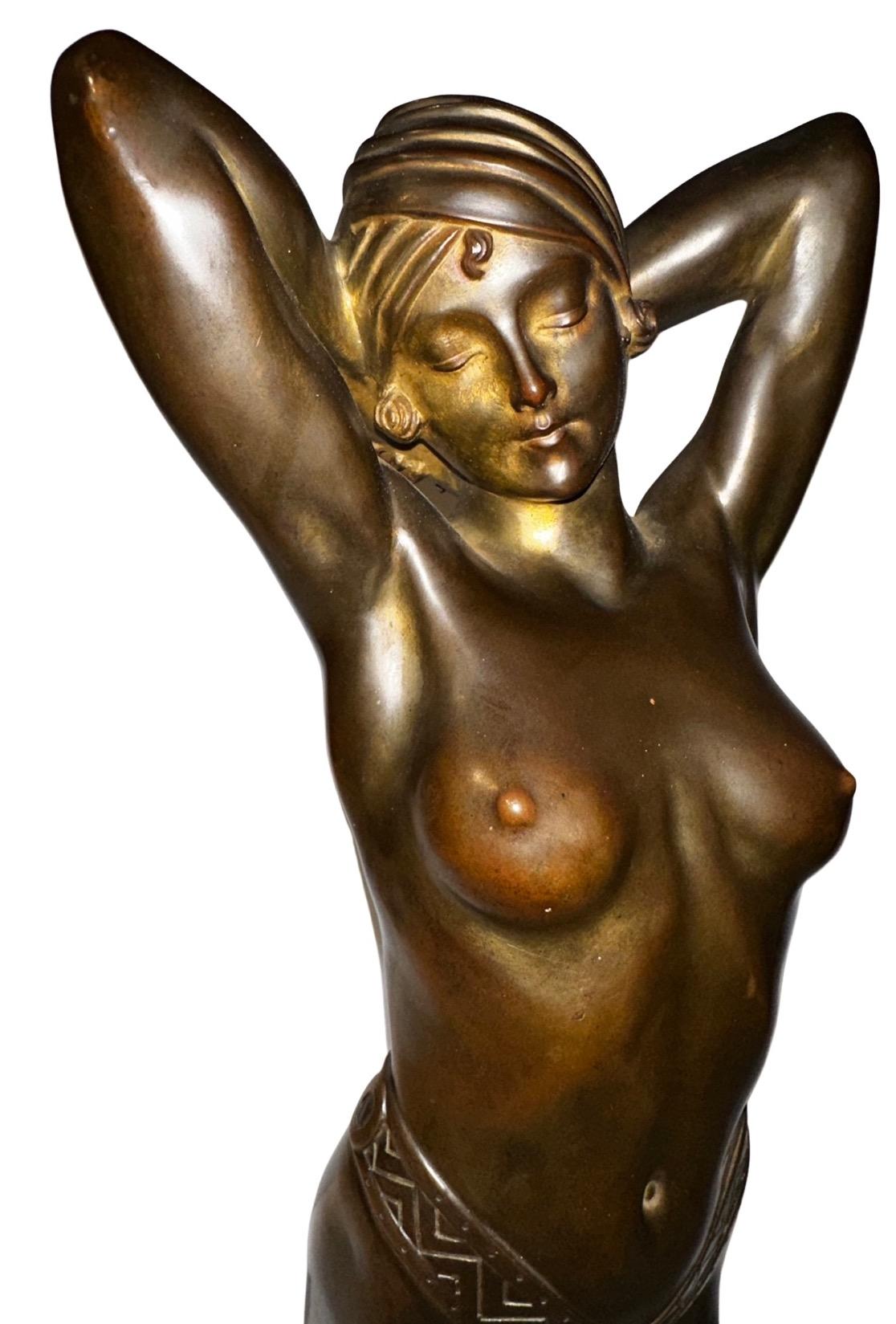 The Art Deco bronze statue portrays a striking sensuous female figure bending with poise and confidence while at the same time, her arms are bent behind her head. Her body exudes the sleek sexy and streamlined aesthetic of the Art Deco era,