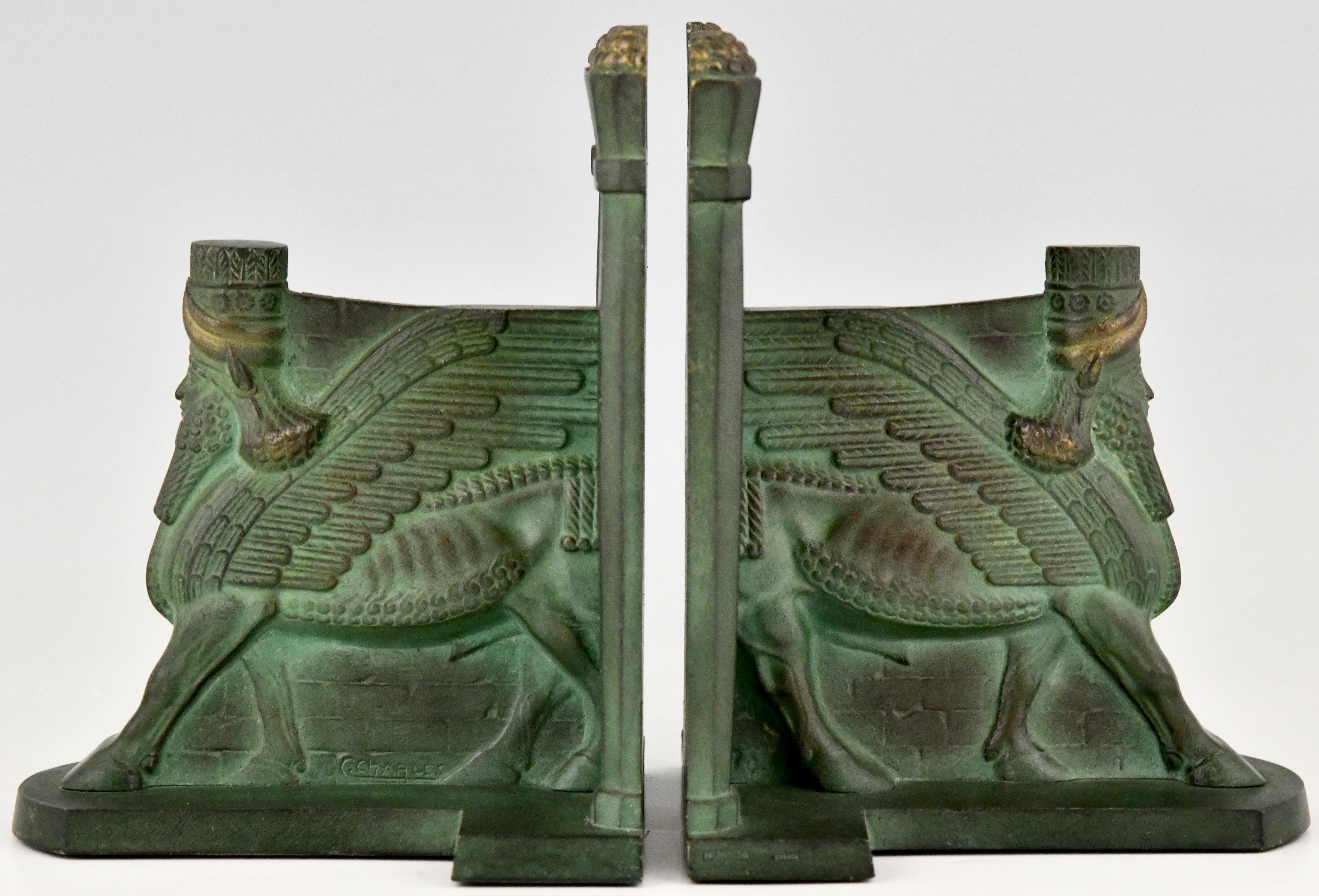 Pair of Art Deco bronze bookends picturing Lamassu, a human headed winged bull, signed by C. Charles.
Egyptian revival, France 1930. 
 
The Lamassu is a mythical creature present in ancient Assyrian architecture. These towering creatures were
