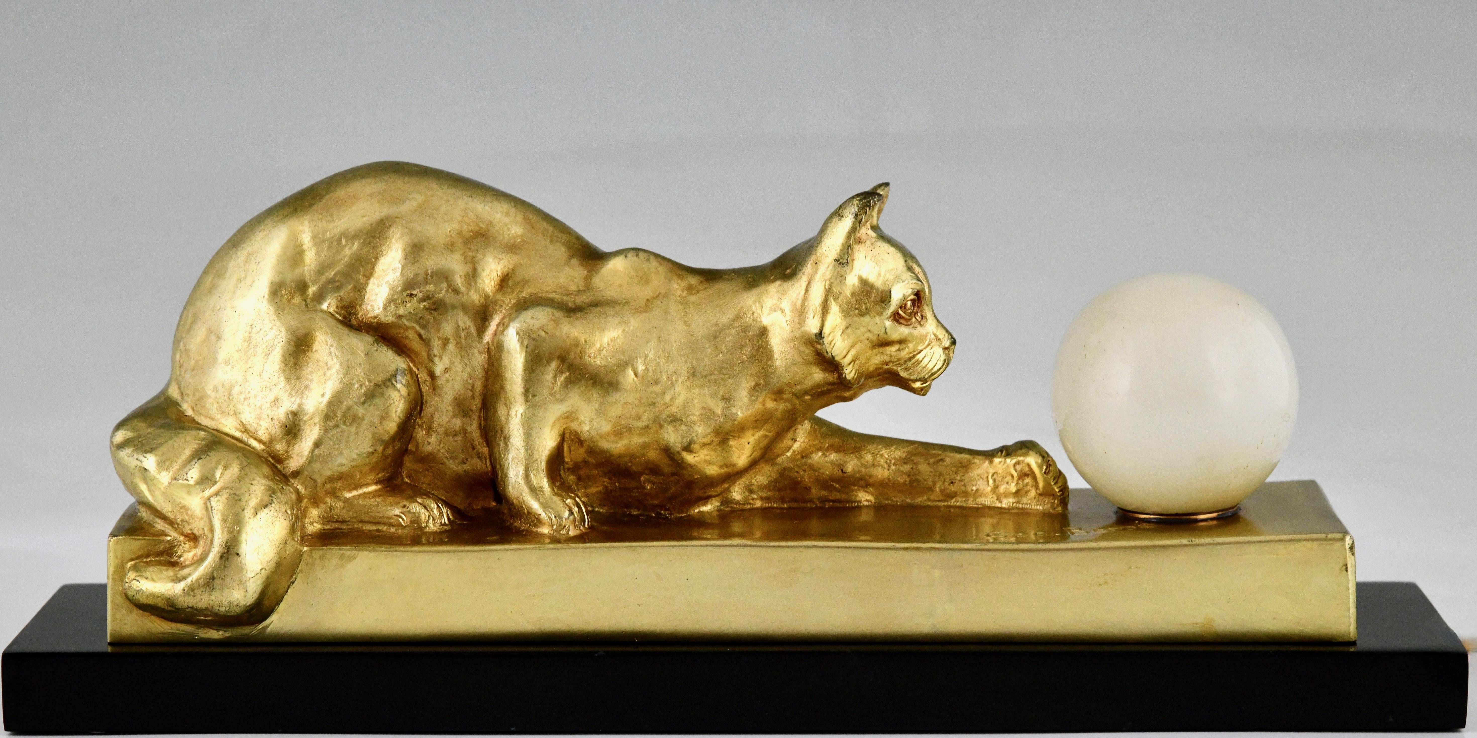 Art Deco bronze lamp sculpture cat with ball by Georges Benoit. 
Foundry Renaud éditeurs Paris. 
Gilt bronze on a Belgian Black marble base. 
Illuminated onyx ball. 
France 1930. 
Literature:	
The dictionary of sculptors in bronze, James Mackay.