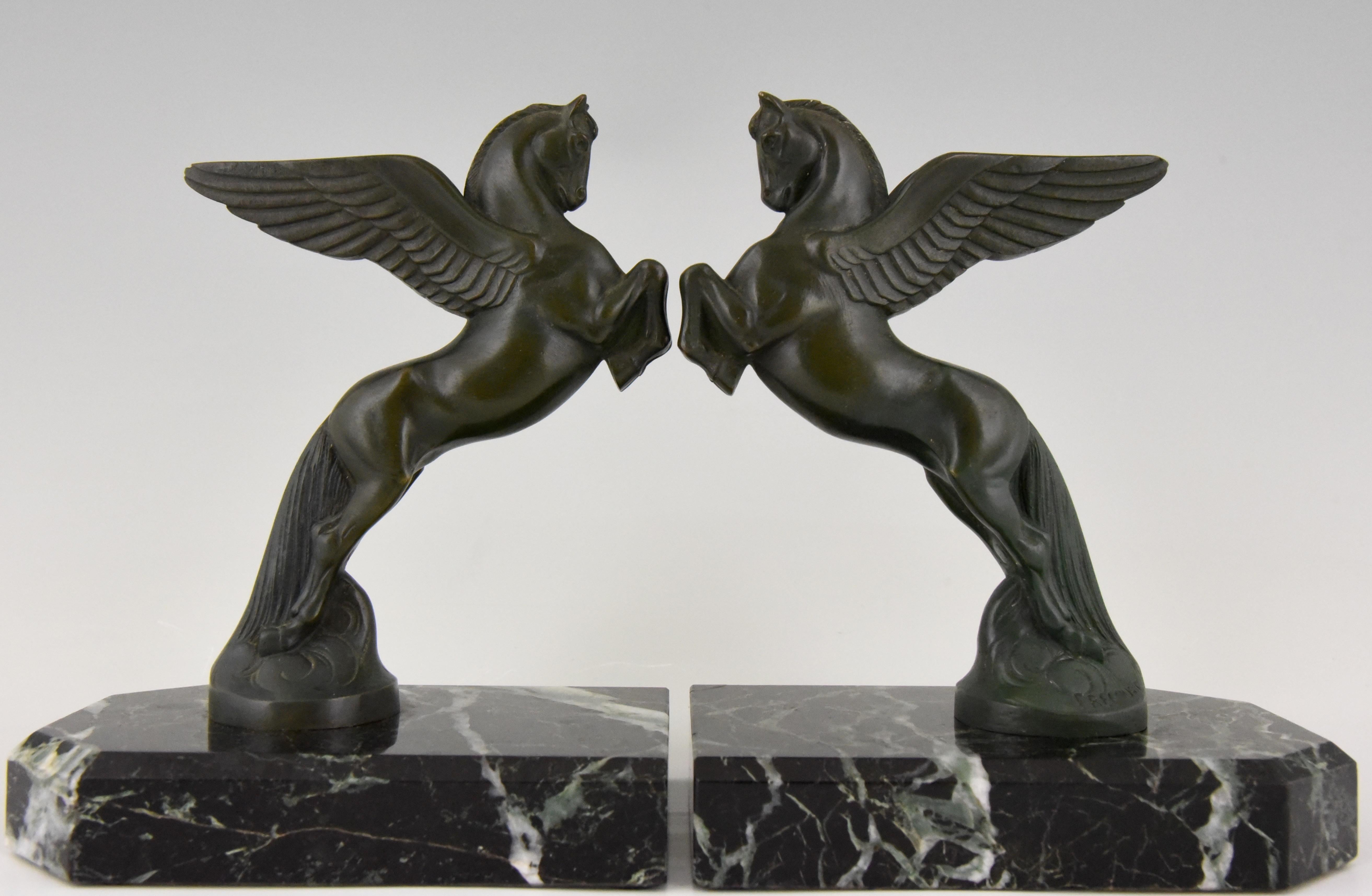 Lovely pair of Art Deco bronze winged horse bookends, Pegasus. 
Signed by the French artist Maurice Frecourt. Beautiful patina. Mounted on green marble bases. France, 1930.