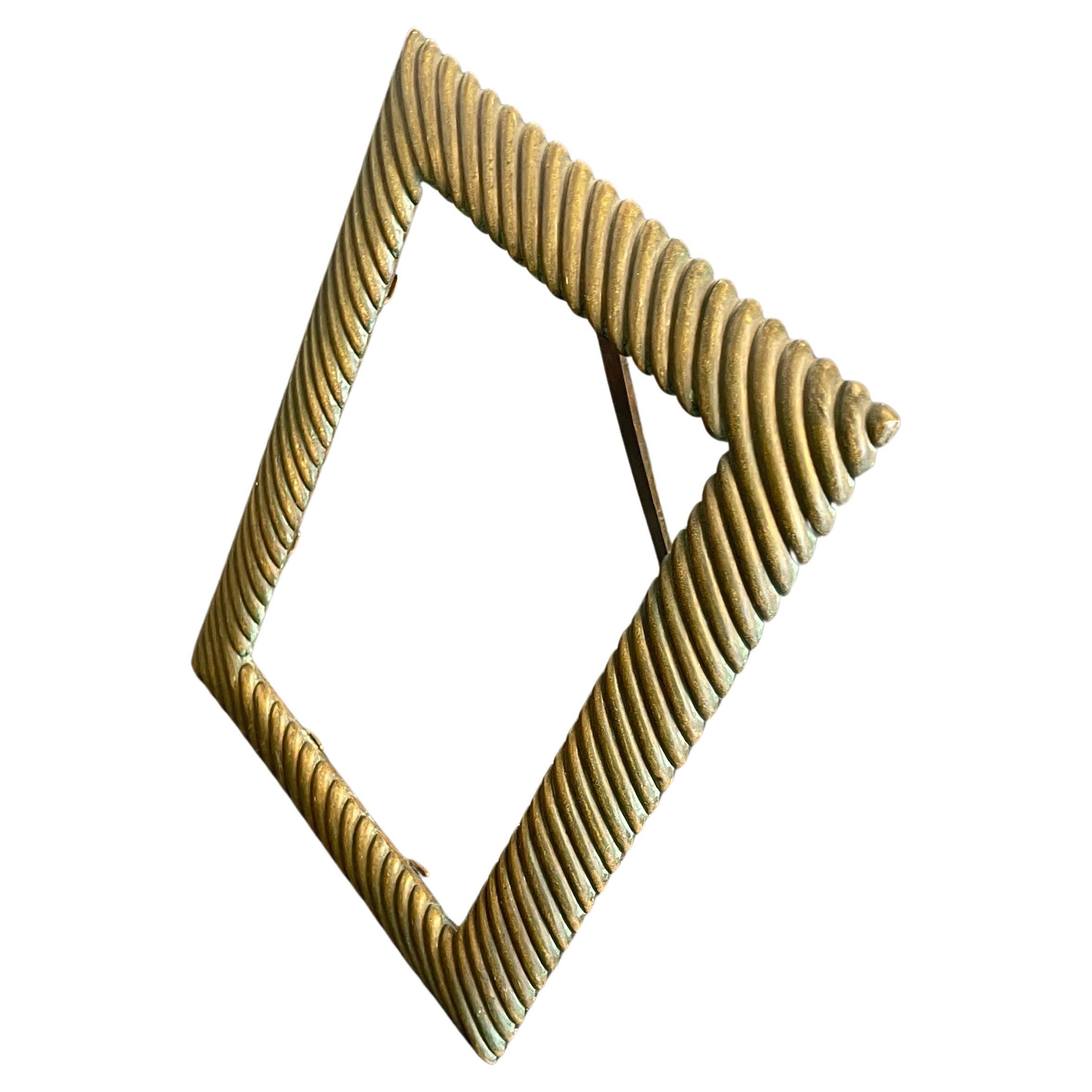 Este precioso marco de bronce está diseñado al estilo Imperio francés. 
El marco puede utilizarse como espejo de tocador o como marco de fotos.
El marco es de forma rectangular, moldeado con un friso horizontal de roleos. El bastidor se fija con