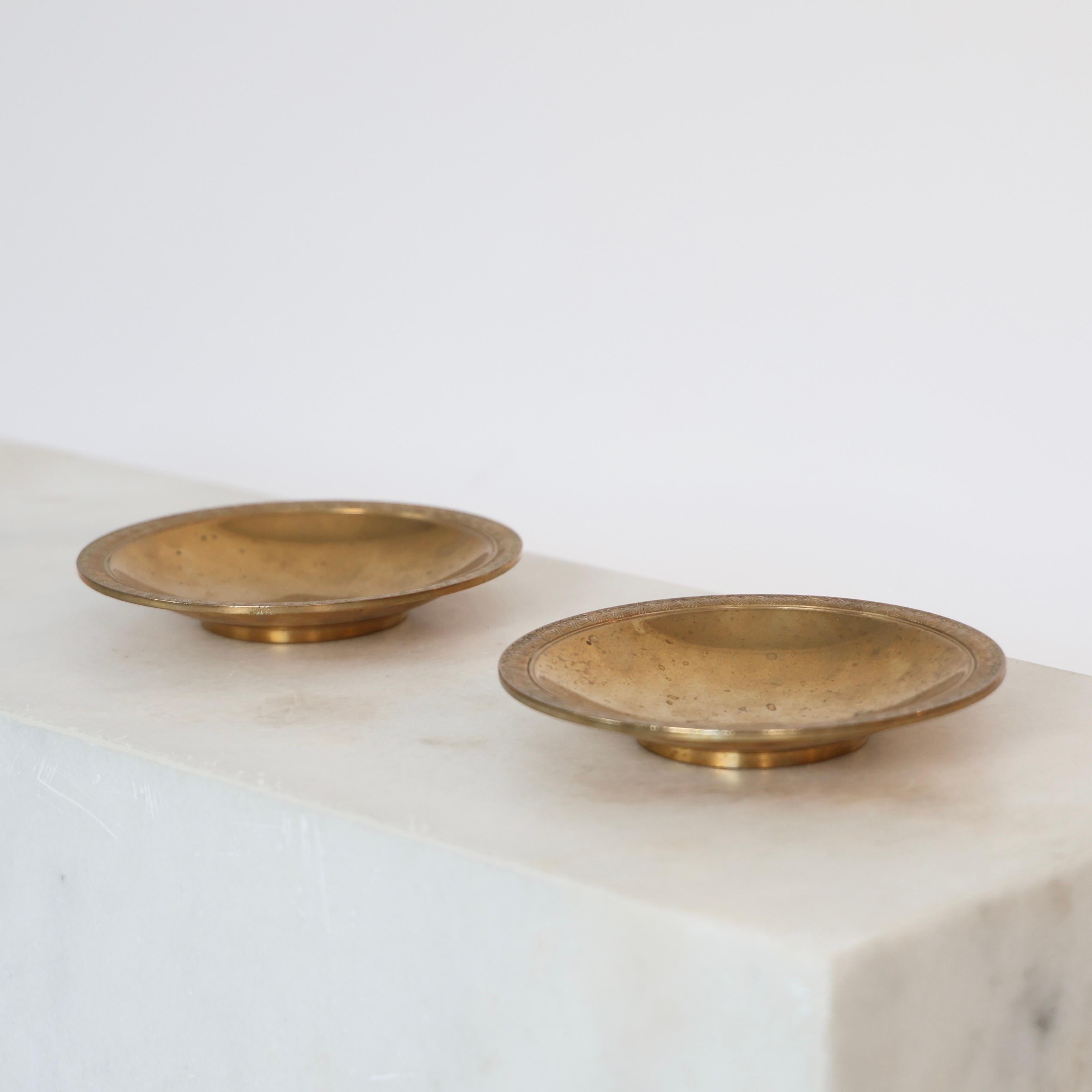 Set Bronze Plates conçu par Just Andersen à la fin des années 1920. 

* Ensemble (2) de plaques en bronze poli avec gravures sur la tranche. 
* Designer : Just Andersen
* Fabricant : Just Andersen
* Modèle : B94 
* Année : 1925-1930 
* Condition :