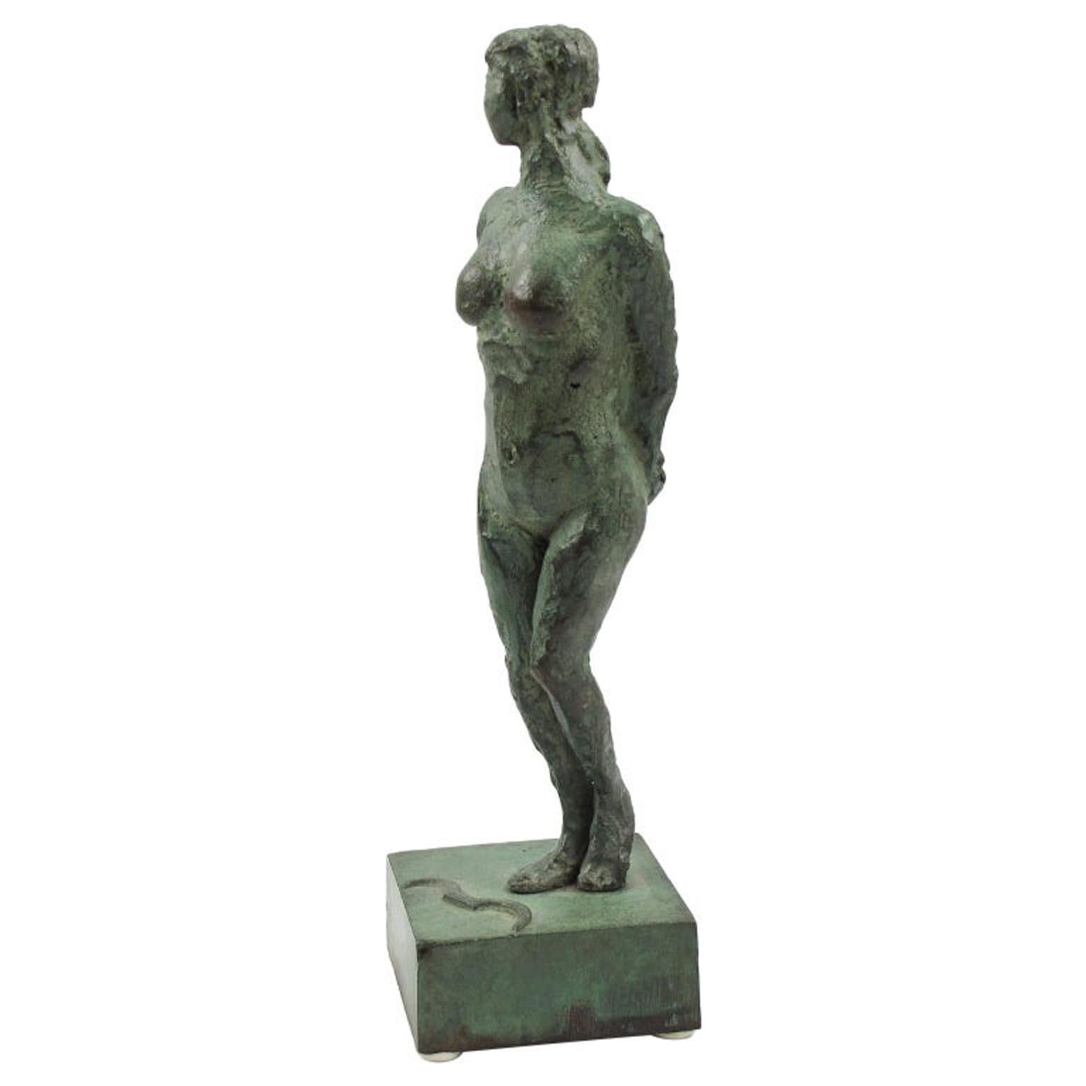 Cette étonnante figurine en bronze de style Art déco français présente une interprétation libre stylisée d'Artemis ou de Diane chasseresse. La statue de femme nue présente un motif texturé fait à la main, les deux bras dans le dos, dans sa patine