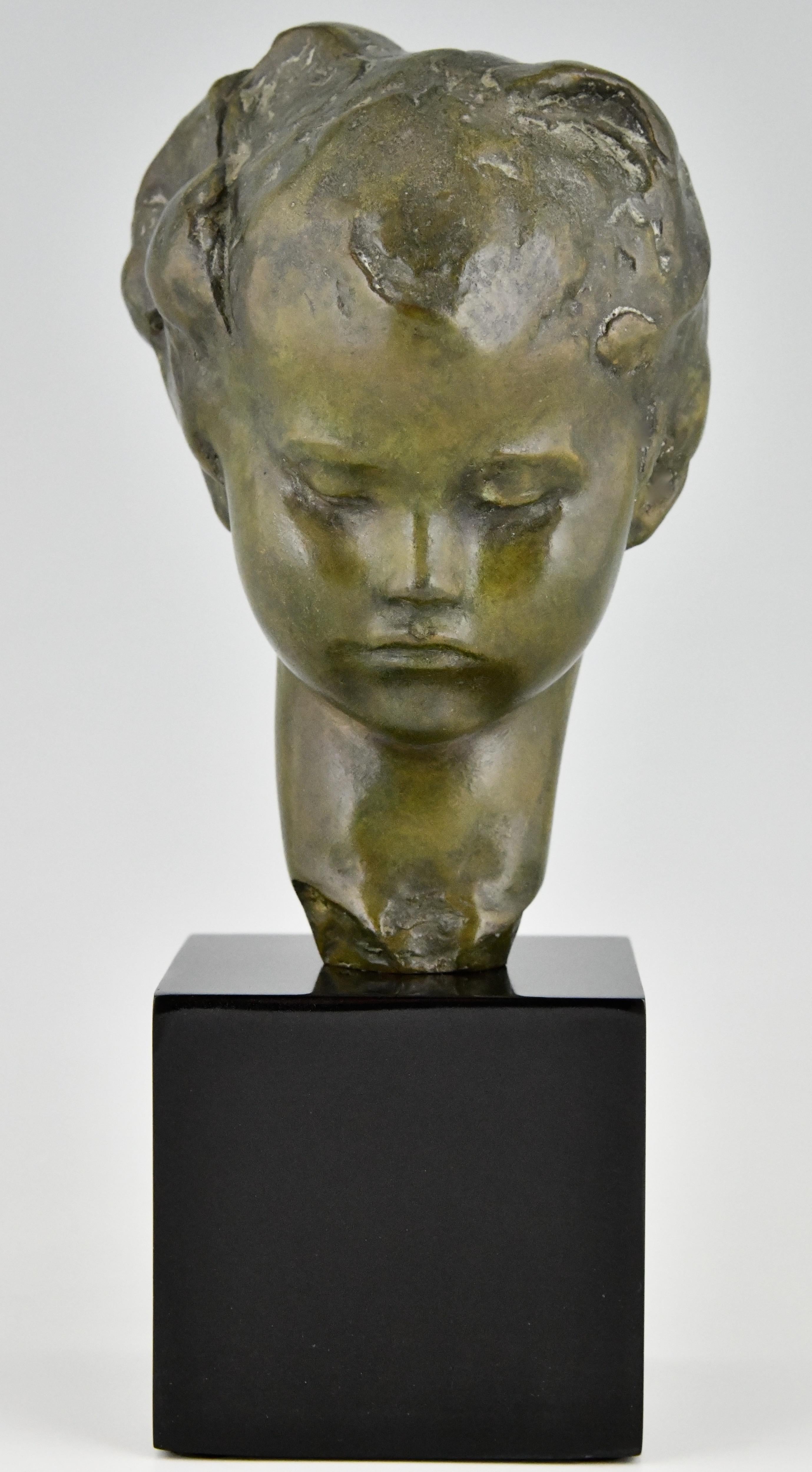 Art Deco bronze sculpture bust of a girl by the artist Amadeo Gennarelli,
who was born in Napels and worked in France
The bust is cast in the lost wax technique, cire perdue, Ca. 1920. 
The patinated bronze head stands on a Belgian Black marble