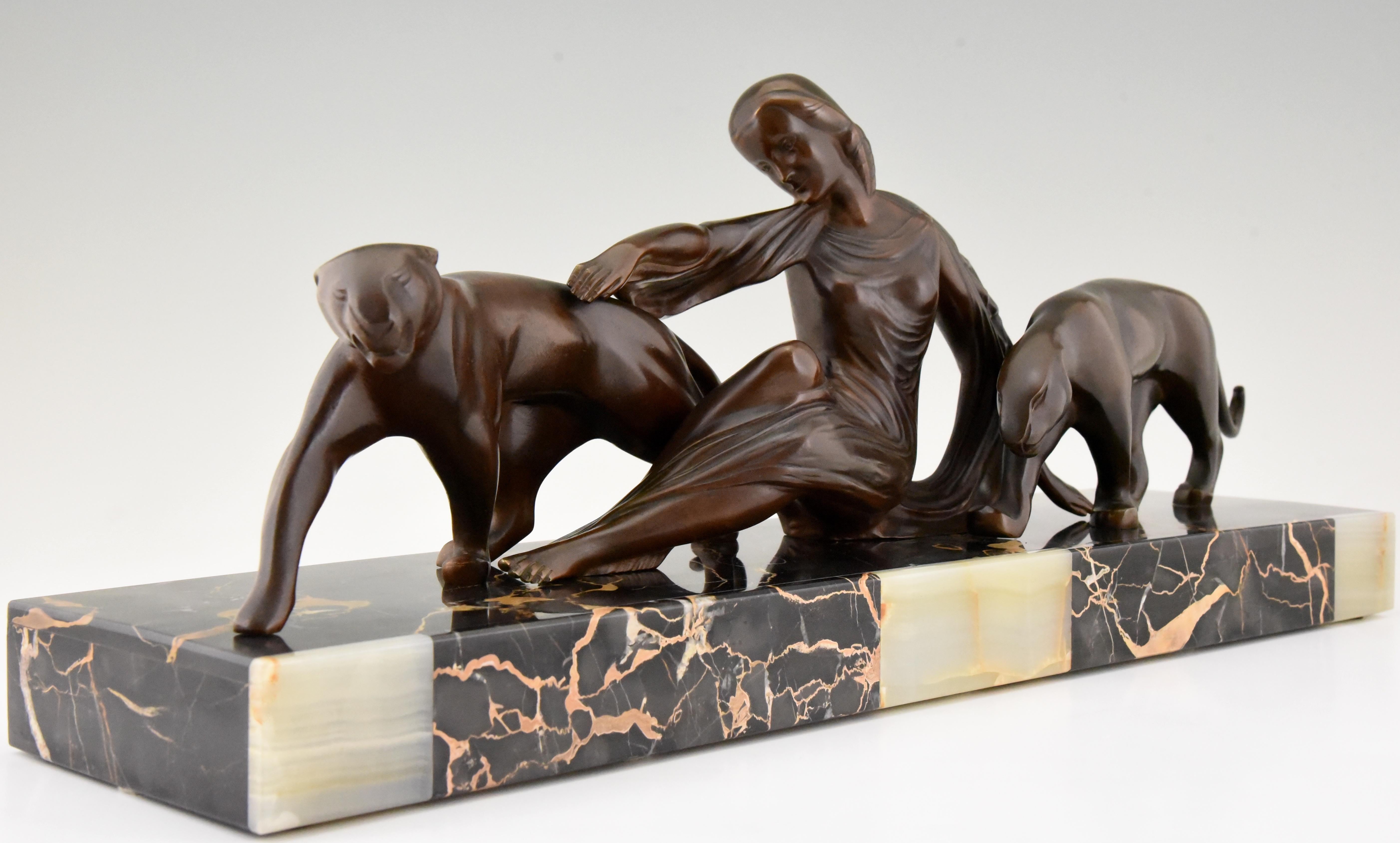 Impressive Art Deco bronze sculpture of a lady with two panthers by the French sculptor Michel Decoux. The bronze has a rich brown patina and stands on a Portor and onyx base. France circa 1925.