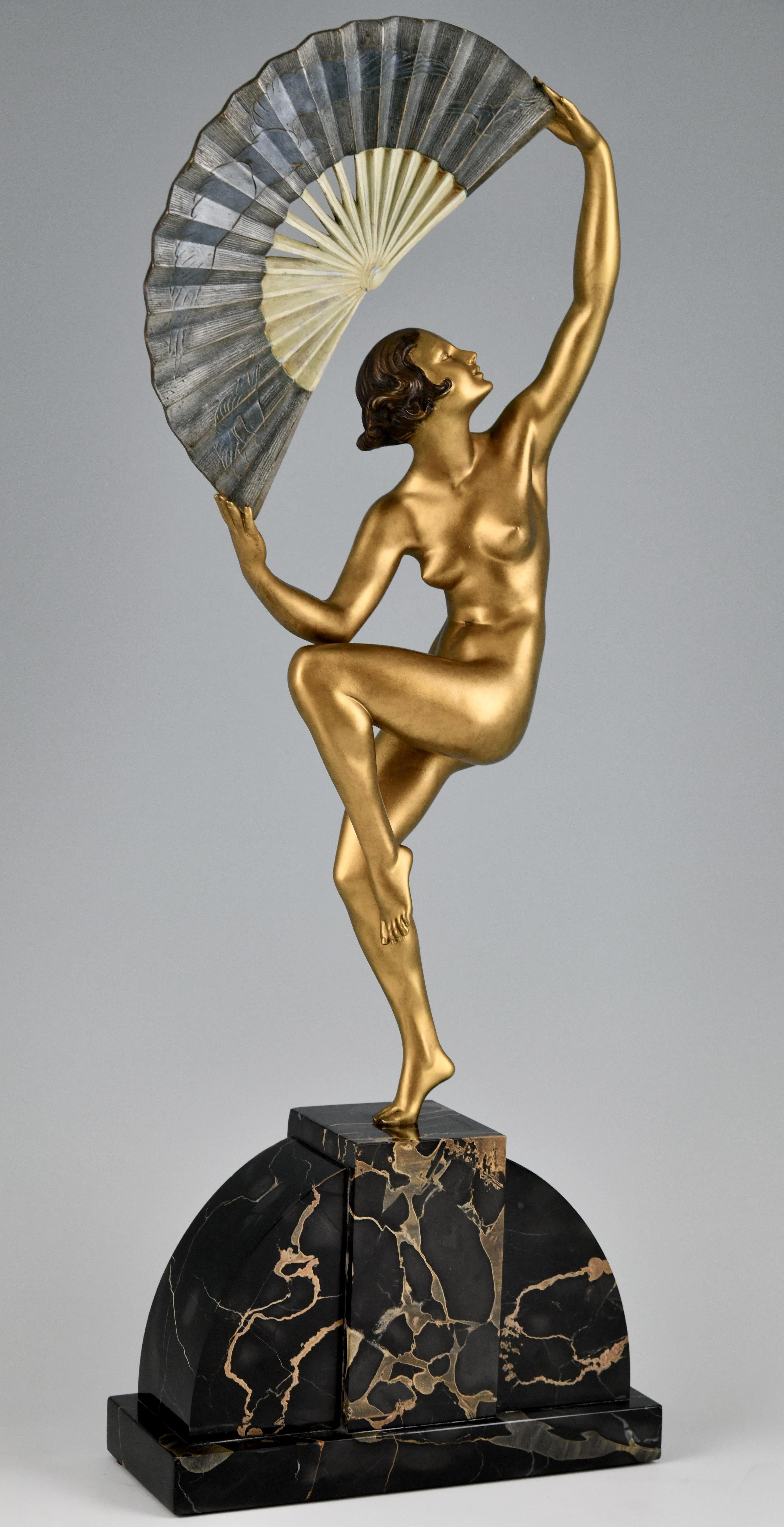 Sculpture en bronze Art déco, danseuse nue à l'éventail.
Sculpture en bronze patiné représentant un nu dansant, debout sur un pied, tenant un éventail incisé d'un motif d'oiseaux.
Le bronze est signé par Marcel André Bouraine, avec la signature des