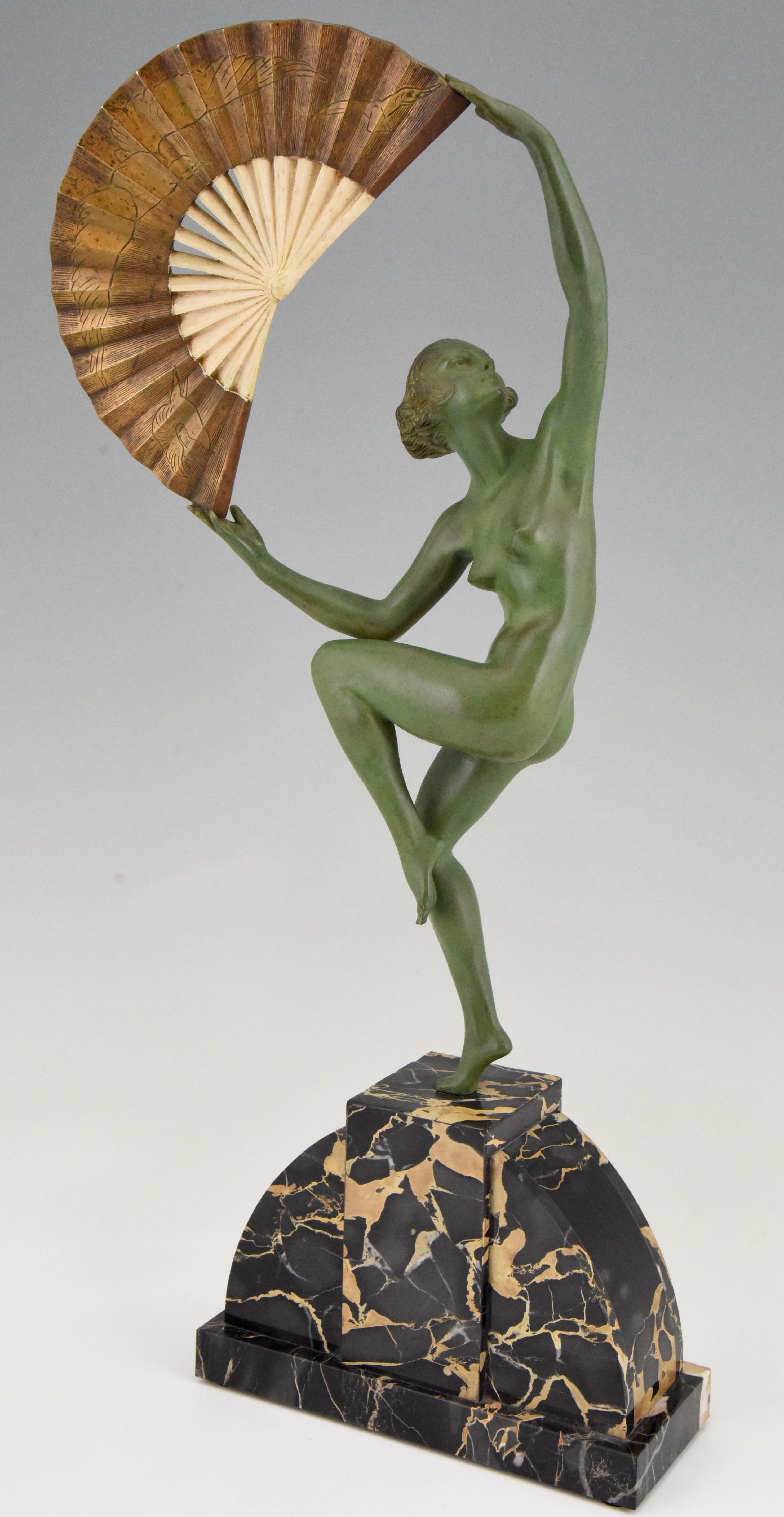 Elegant Art Deco bronze sculpture of a dancing nude standing on one foot holding a fan incised with a design of birds.
The bronze is signed by Marcel André Bouraine.
The sculpture has a lovely patina and stands on a fine Portor marble base. This