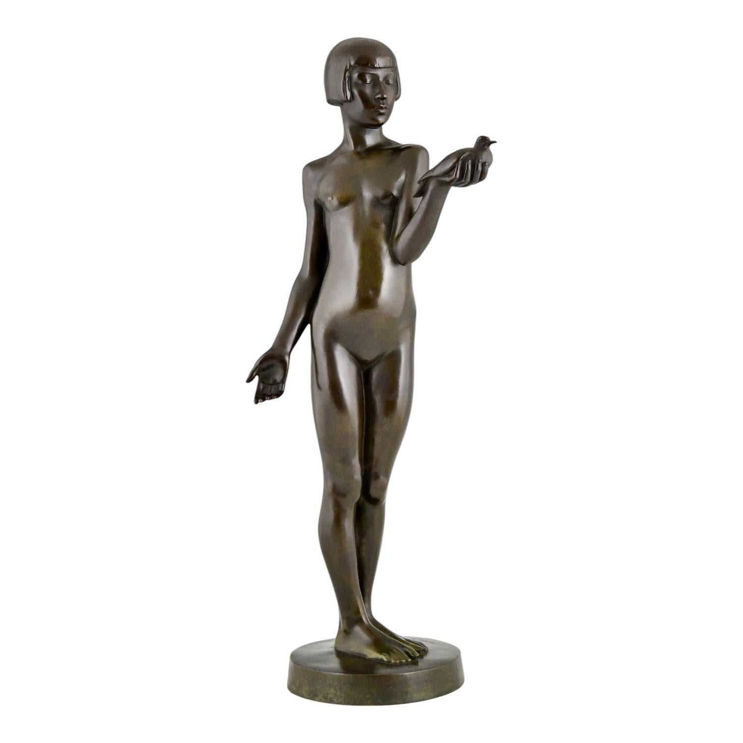 Escultura Art Decó en bronce de chica desnuda con paloma, de Henry Arnold. 
Première offrande.
Con sello de fundición y firma Susse Frères éditeurs París. Francia 1928. 
H. 67 cm. / 26,4 pulg. 
Este bronce fue presentado en el Salón de Otoño de 1928