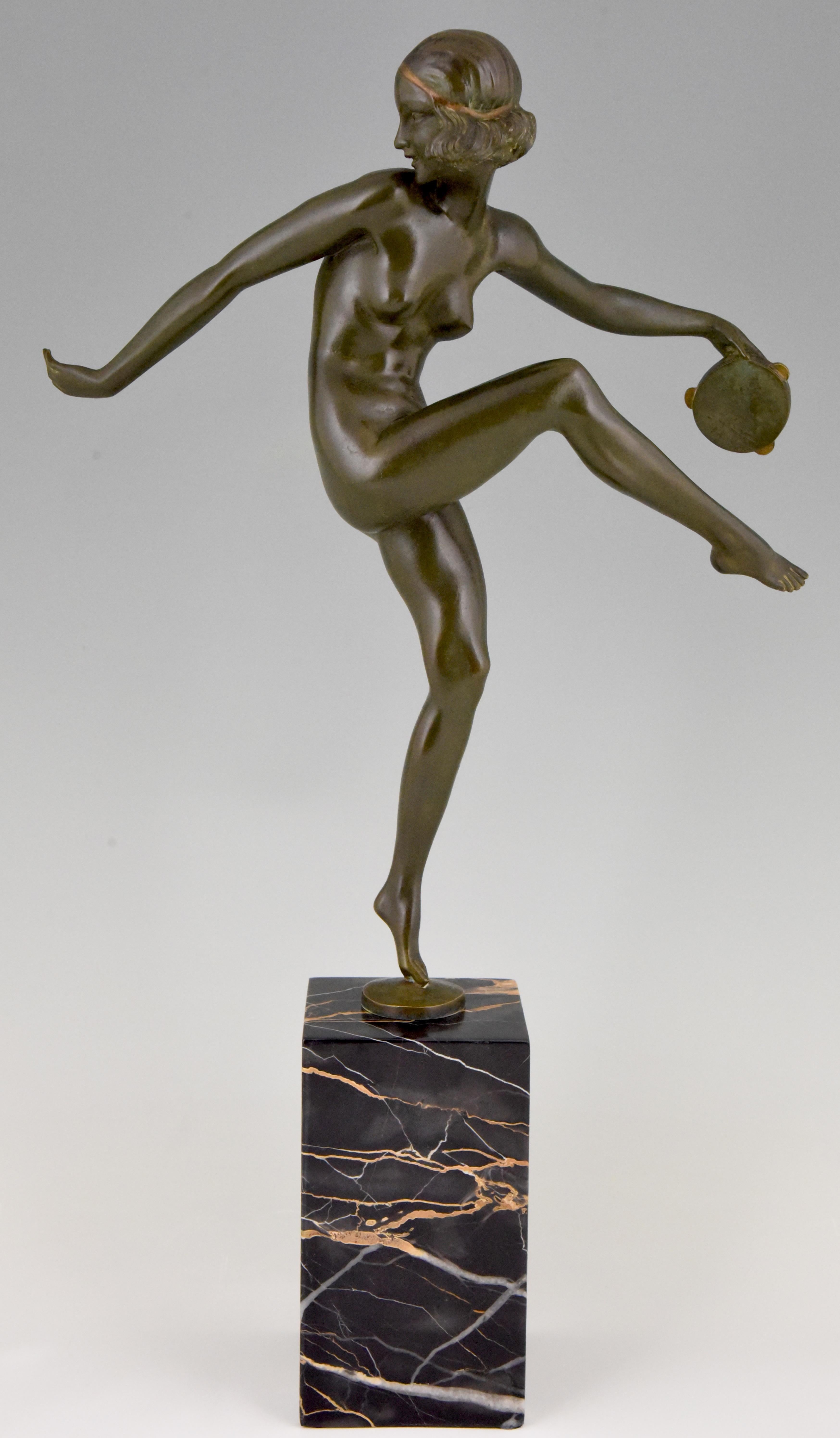 Elegant Art Deco bronze sculpture of a dancing nude with tambourine. The bronze has a lovely patina and stands on a Portor marble base. The sculpture is signed Laurel, pseudonym of Pierre Le Faguays, is numbered and has the foundry mark of Marcel