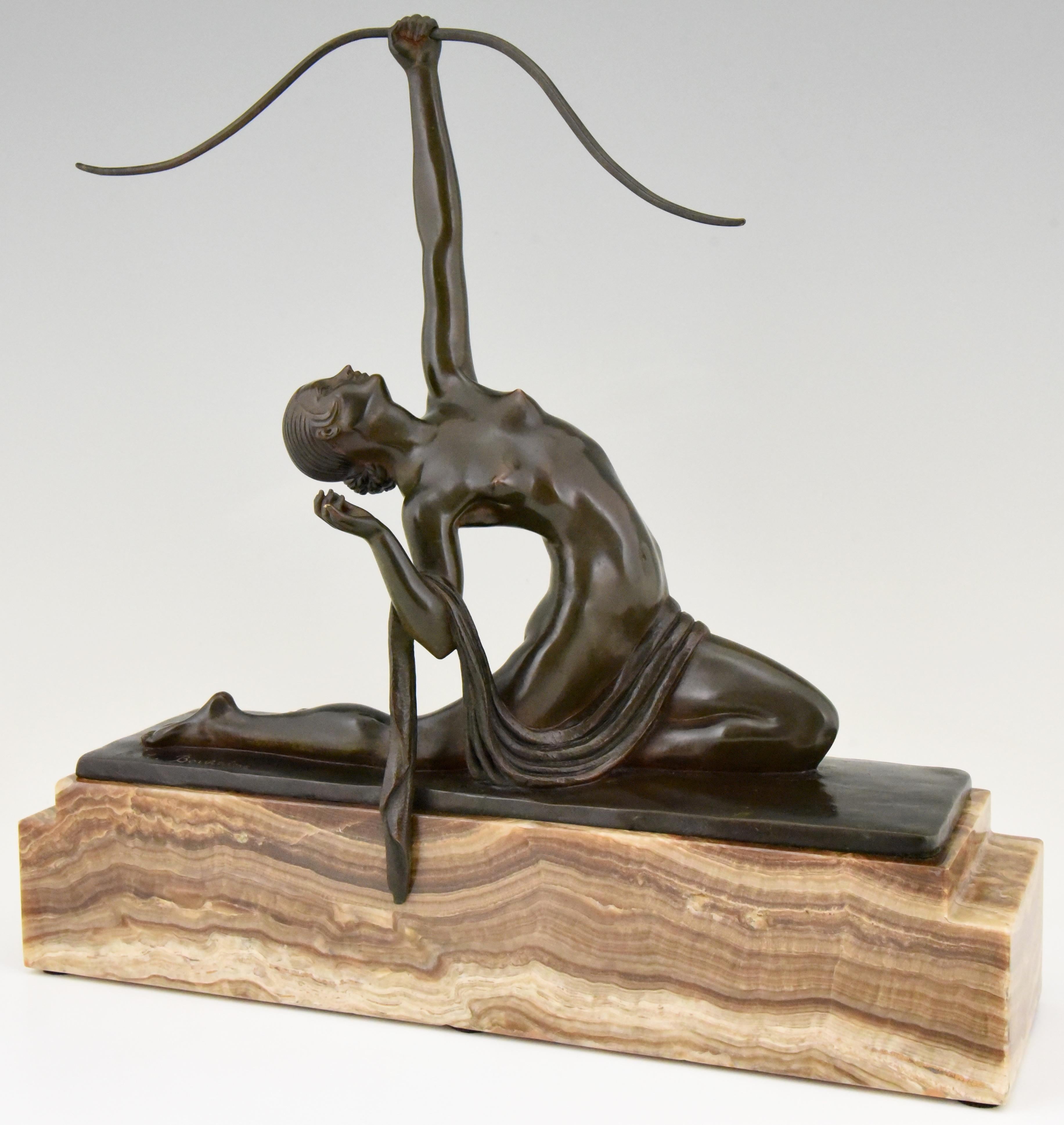 Diana, female archer. A bronze by Marcel Bouraine of a naked young woman with length of cloth draped across lap, kneeling backwards and aiming with a bow towards the sky. On a stepped rectangular marble base.
Literature:
This model is illustrated