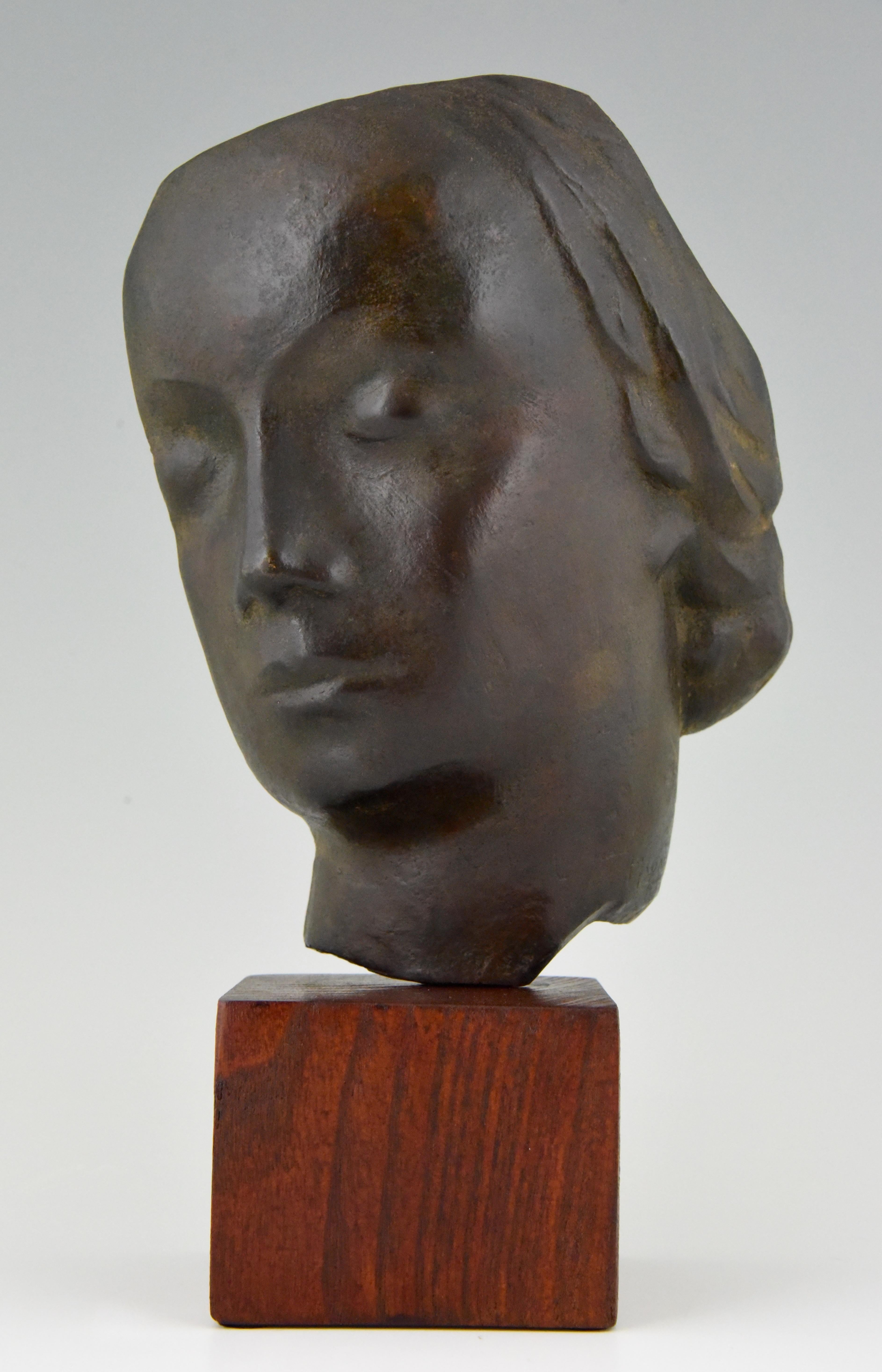 Hard to find bronze Art Deco sculpture of a woman's face by the French sculptor Francisque Lapandery, 1910-1961. The bronze has a black patina and stands on a wooden base. The artist lived and worked in Lyon.