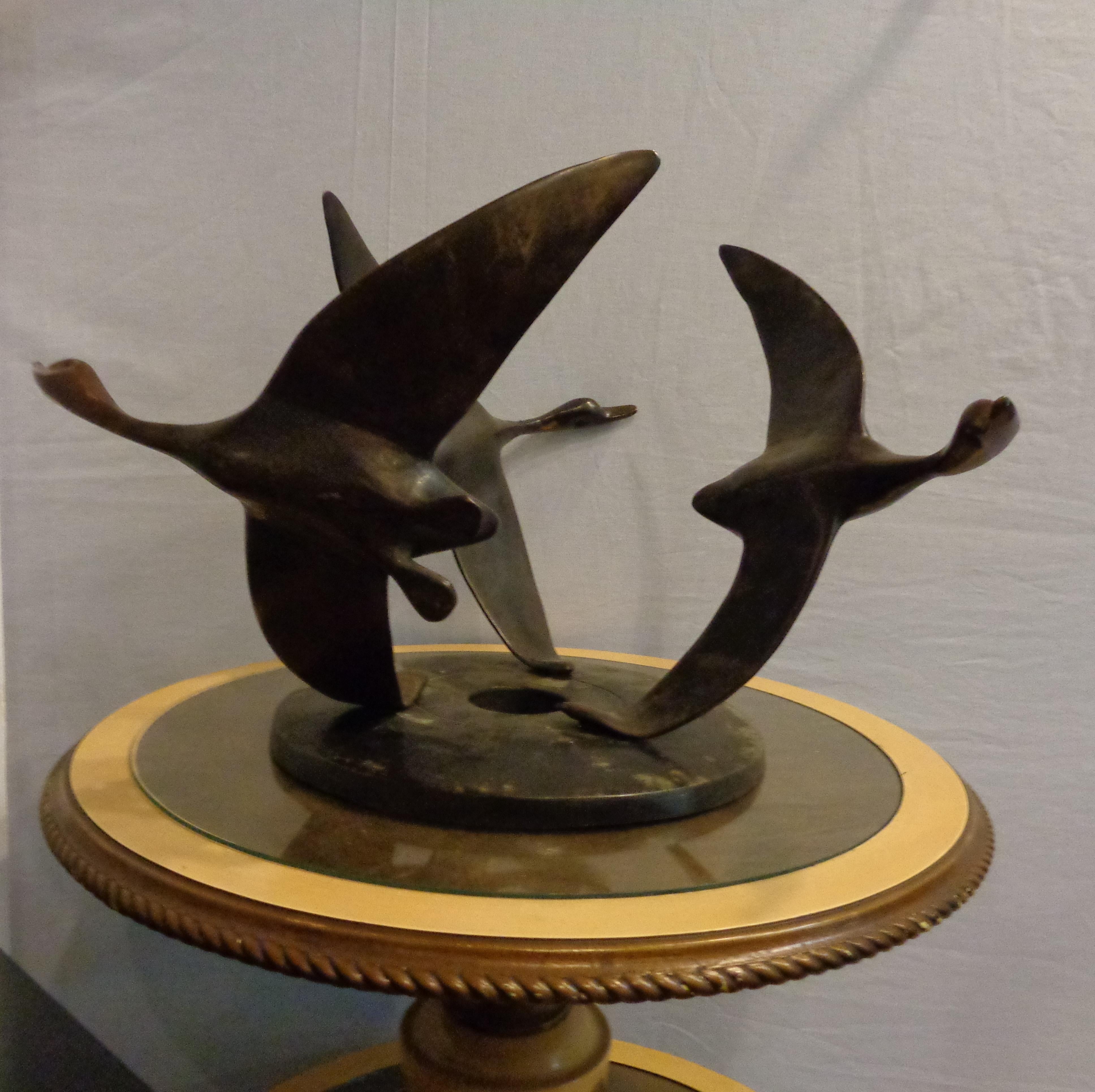 An Art Deco bronze sculpture of flying geese on an adjustable base. Finely cast decorative sculpture of large geese which are movable on a circular disk tray.