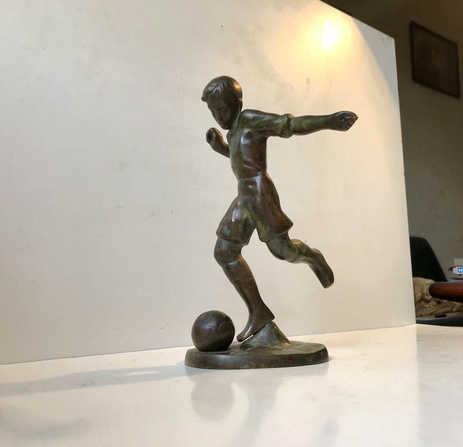 Patinated bronze sculpture of young soccer player. The moment just before the kick is captured. A moment with stylized movement and perfect balance. This Art Deco sculpture in solid bronze was made in Scandinavia during the 1930s. It shows a deep