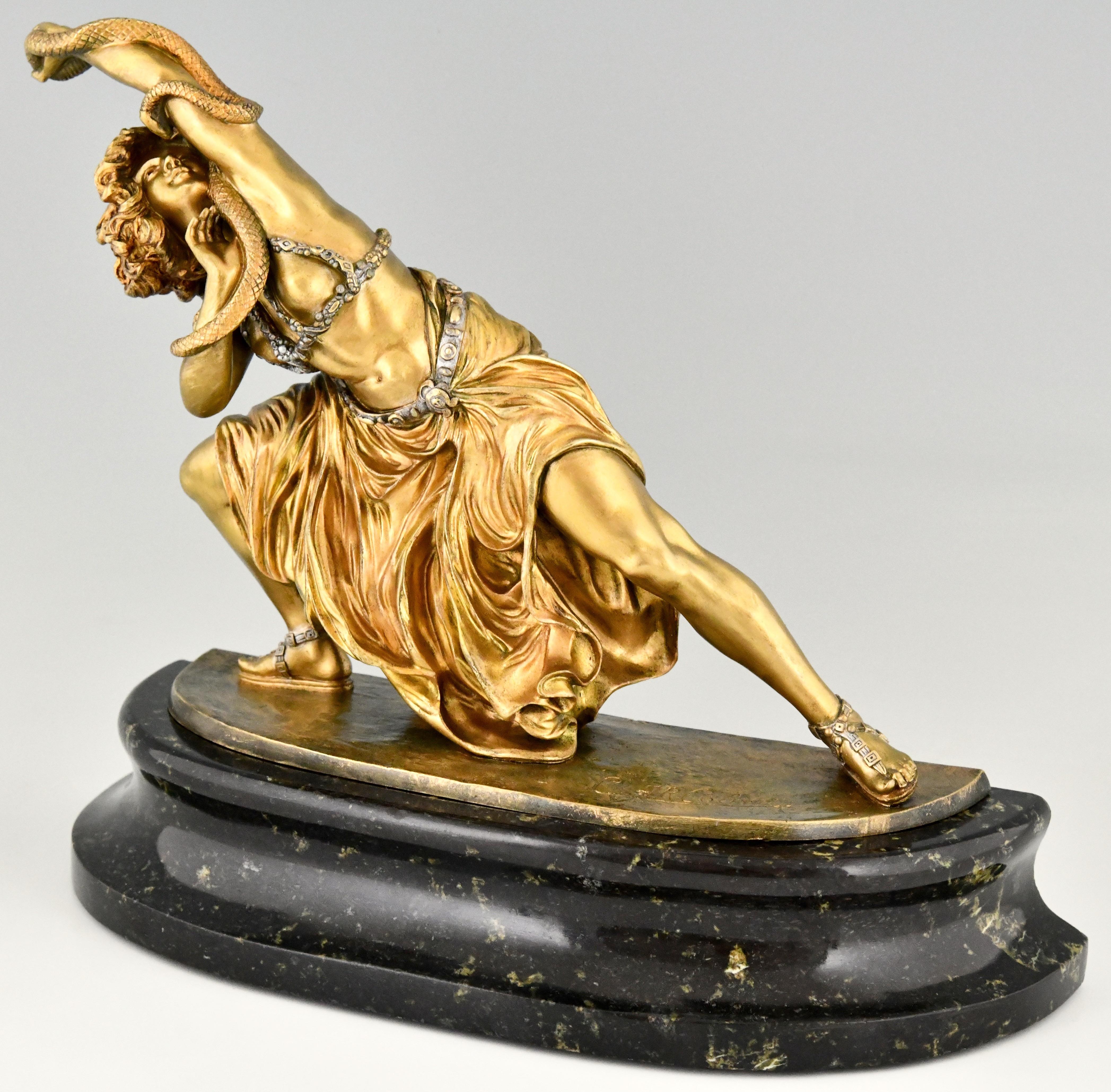 Dance of Carthage, Art Deco bronze sculpture of an oriental dancer with snake by Claire Jeanne Roberte Colinet. The bronze has a gilt patina with silver accents and stands on a fine marble base.
France, ca. 1925.
This model is very hard to find &