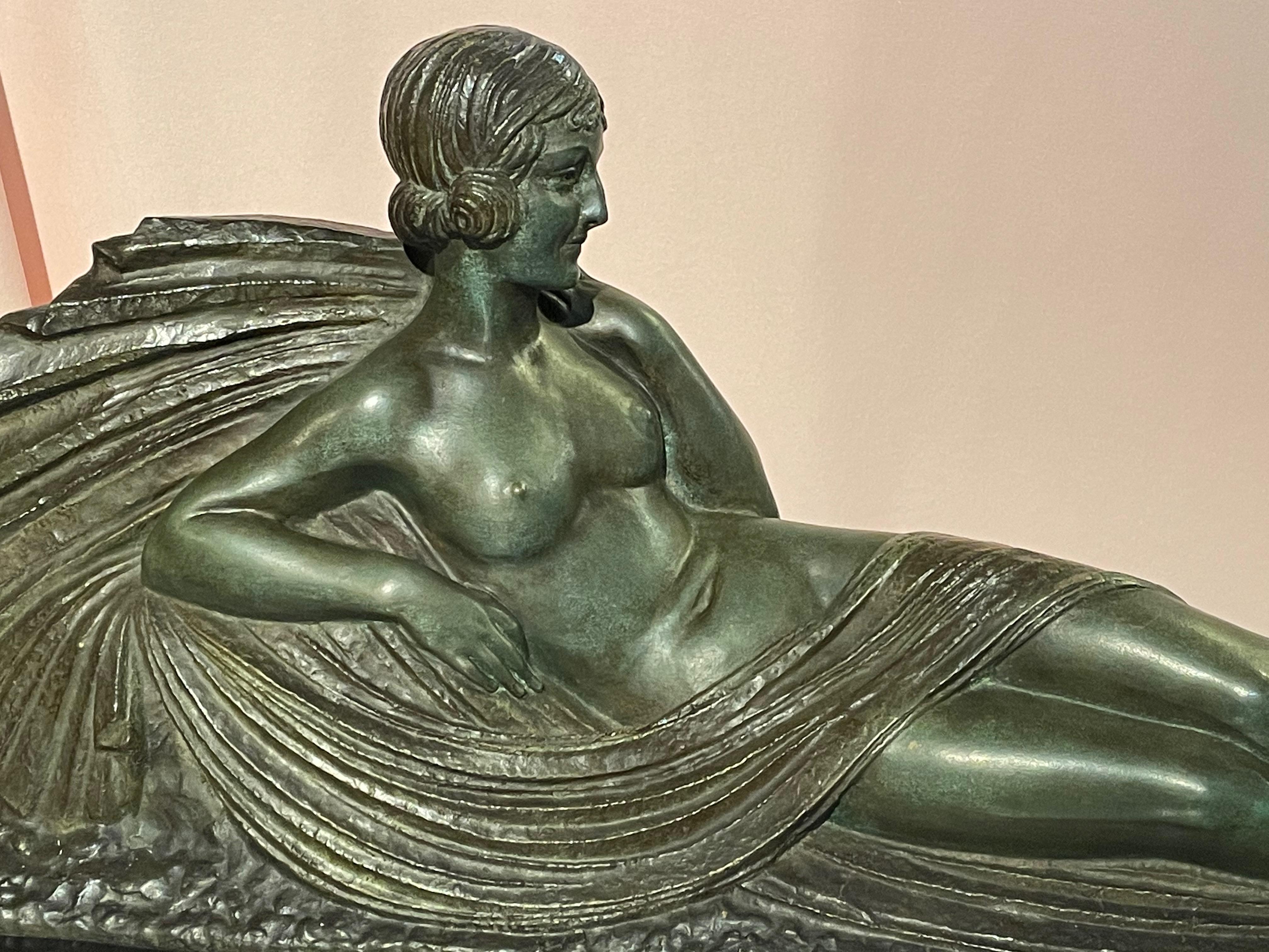An Art Deco bronze sculpture by Darcles entitled “Nu Allonge” (Reclining Nude) on a marble base. Created in 1925 and embodying all the stylistic elements of the Deco Era and executed by the master sculptor “Darcles”. The period hairstyle in rolls