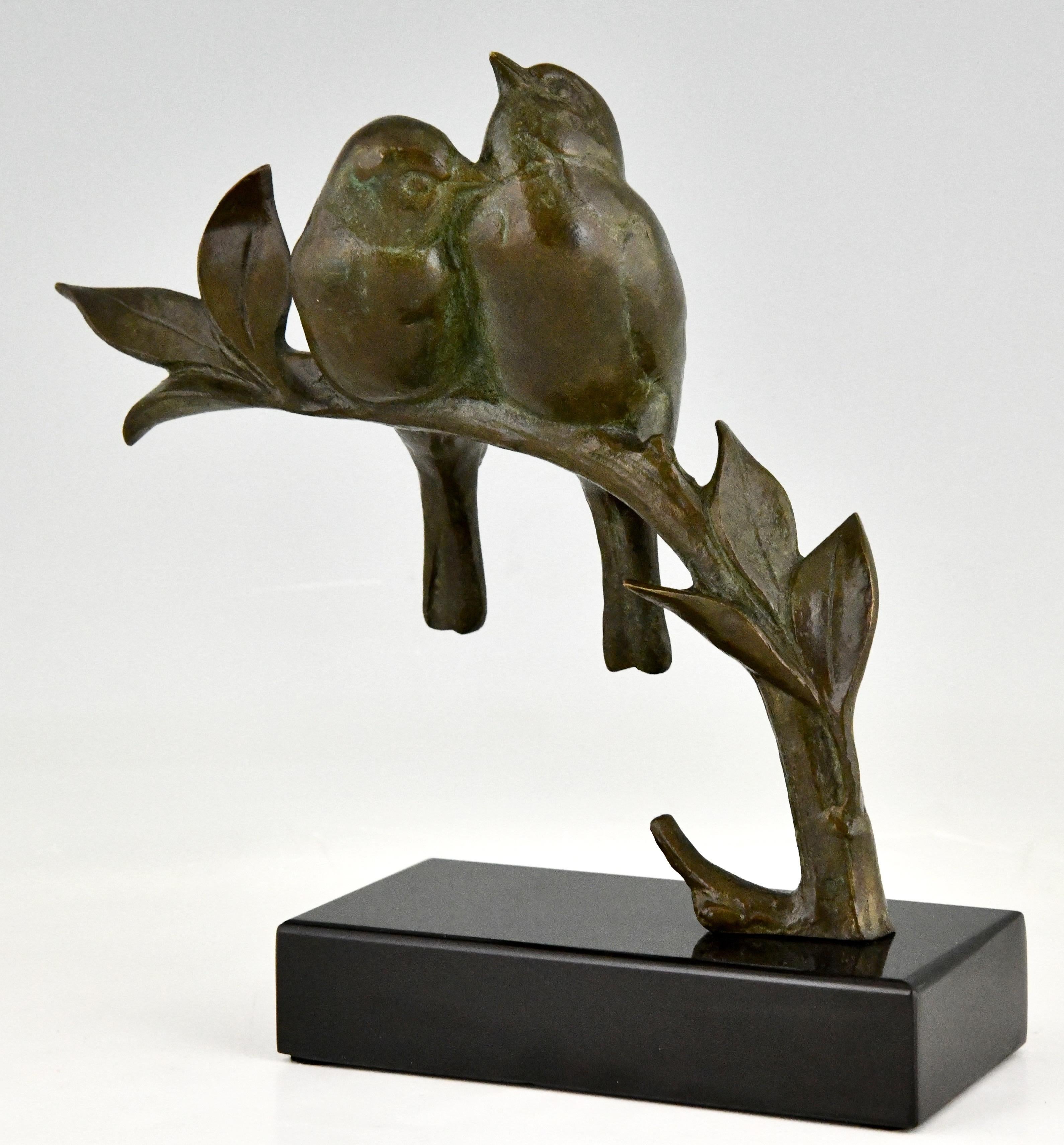 Art Deco bronze sculpture of two birds sitting on a branch signed by the French artist Andre Vincent Becquerel. The bronze statue has a lovely green patina. The lovebirds are mounted on a Belgian Black marble base. France 1930.