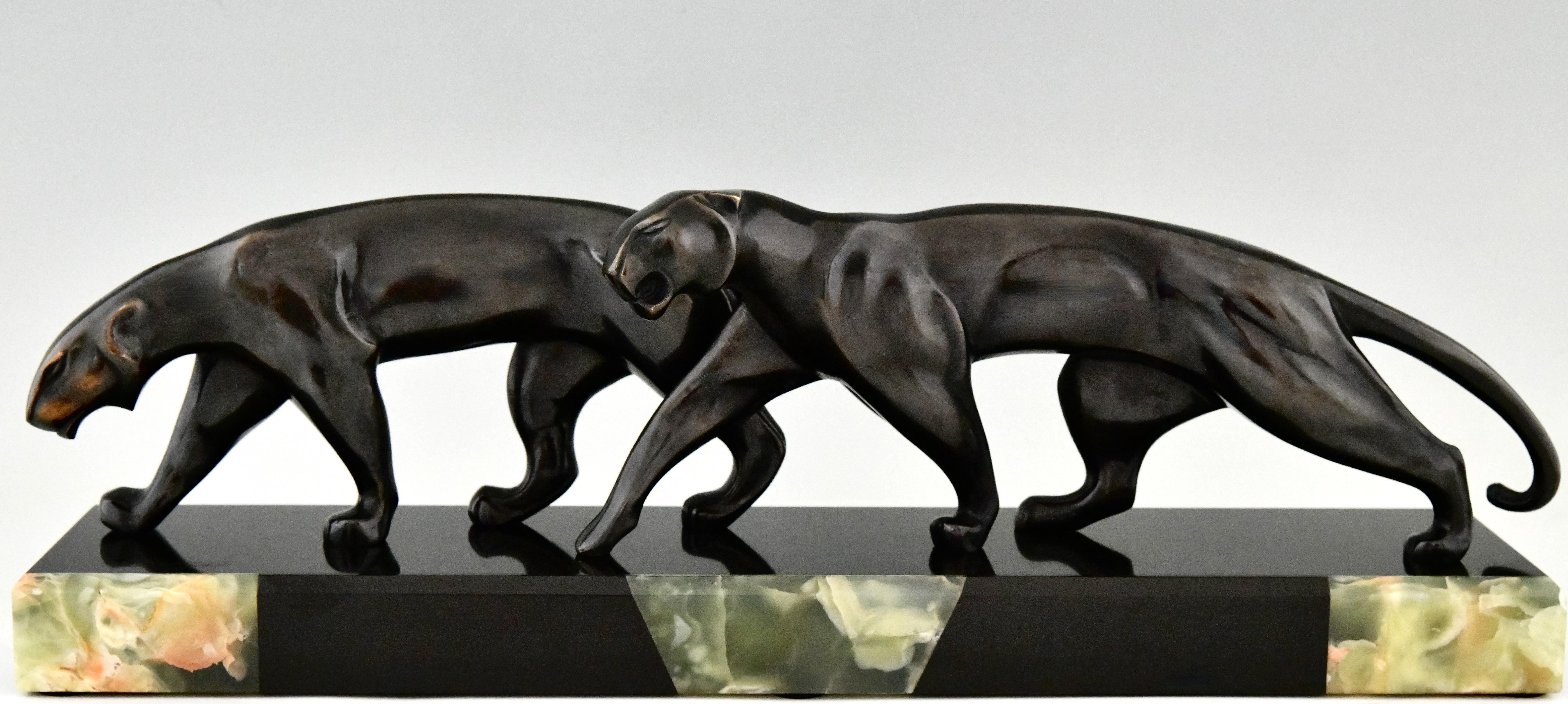 Art Deco Bronze-Skulptur zwei Panther signiert von Michel Decoux.
Bronze, schwarz patiniert, auf schwarzem Marmorsockel mit grüner Onyxeinlage. 
Frankreich 1920. 
Dieses Modell ist auf Seite 294 des Buches abgebildet
Dictionnaire illustré des