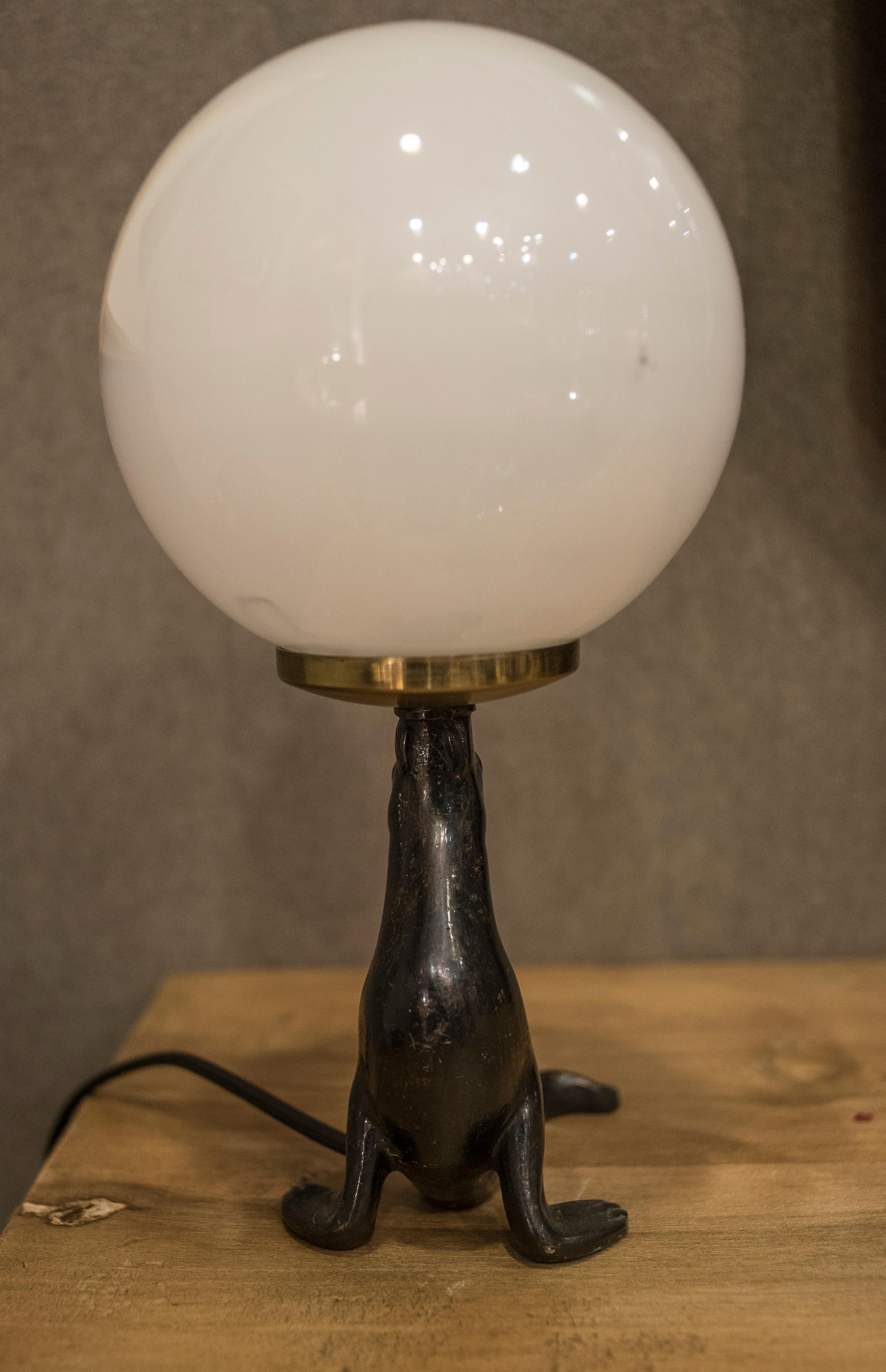 Awesome French Art Deco table lamp with a amazing bronze seal figure and a glass globe. In a perfect condition.