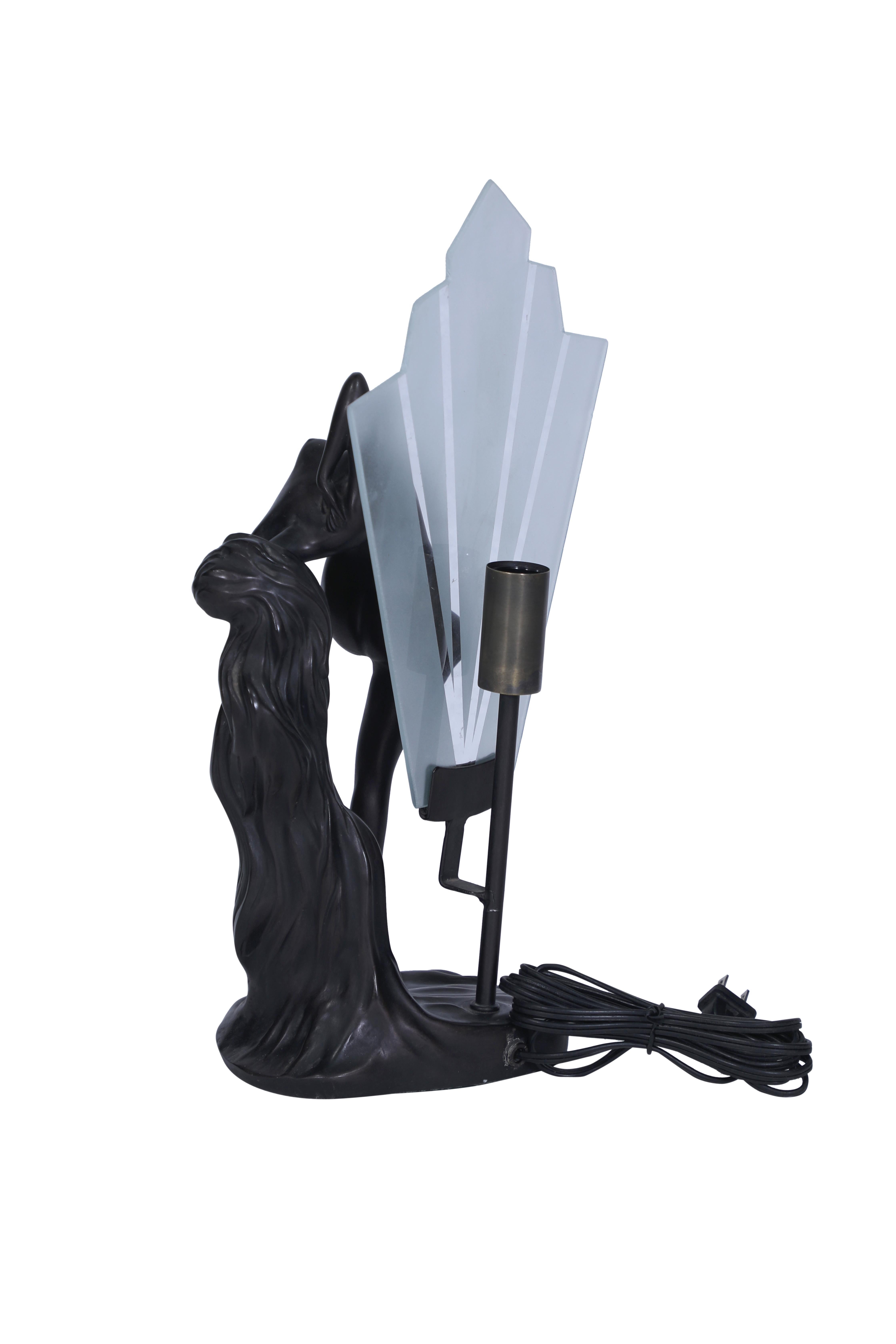 A lovely and sexy bronze Art Deco table lamp featuring a naked woman figure.  A frosted tapered glass plate shade ahead of the bulb.  It takes an E-14 European base bulb, which is easy to find.  It has been rewired for American use.

The Lockhart