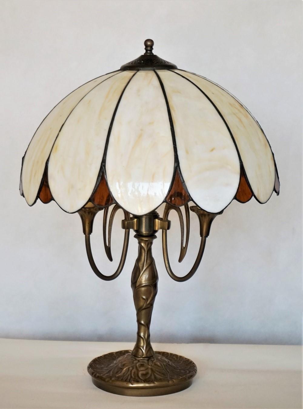 Early Art Deco bronze table lamp from 1910-1920. Dome form shade with twelve bent slag glass panels on a large bronze foliarte base with integrated central three-light candelabra bulb holder. This beautiful lamp is in very good condition and has