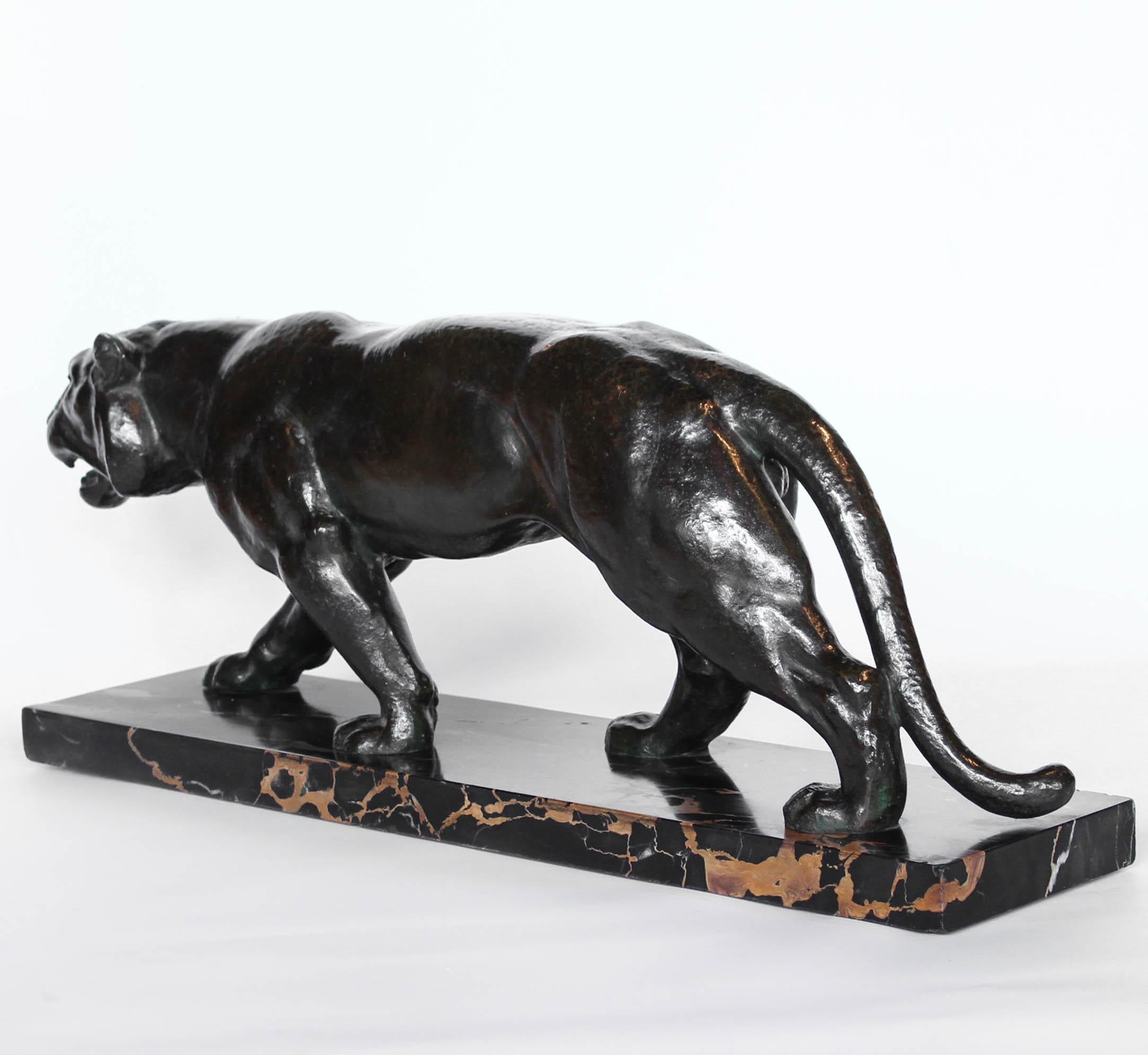 An Art Deco, patinated bronze study of a prowling tiger, set over an integral marble base. Signed to marble. 






