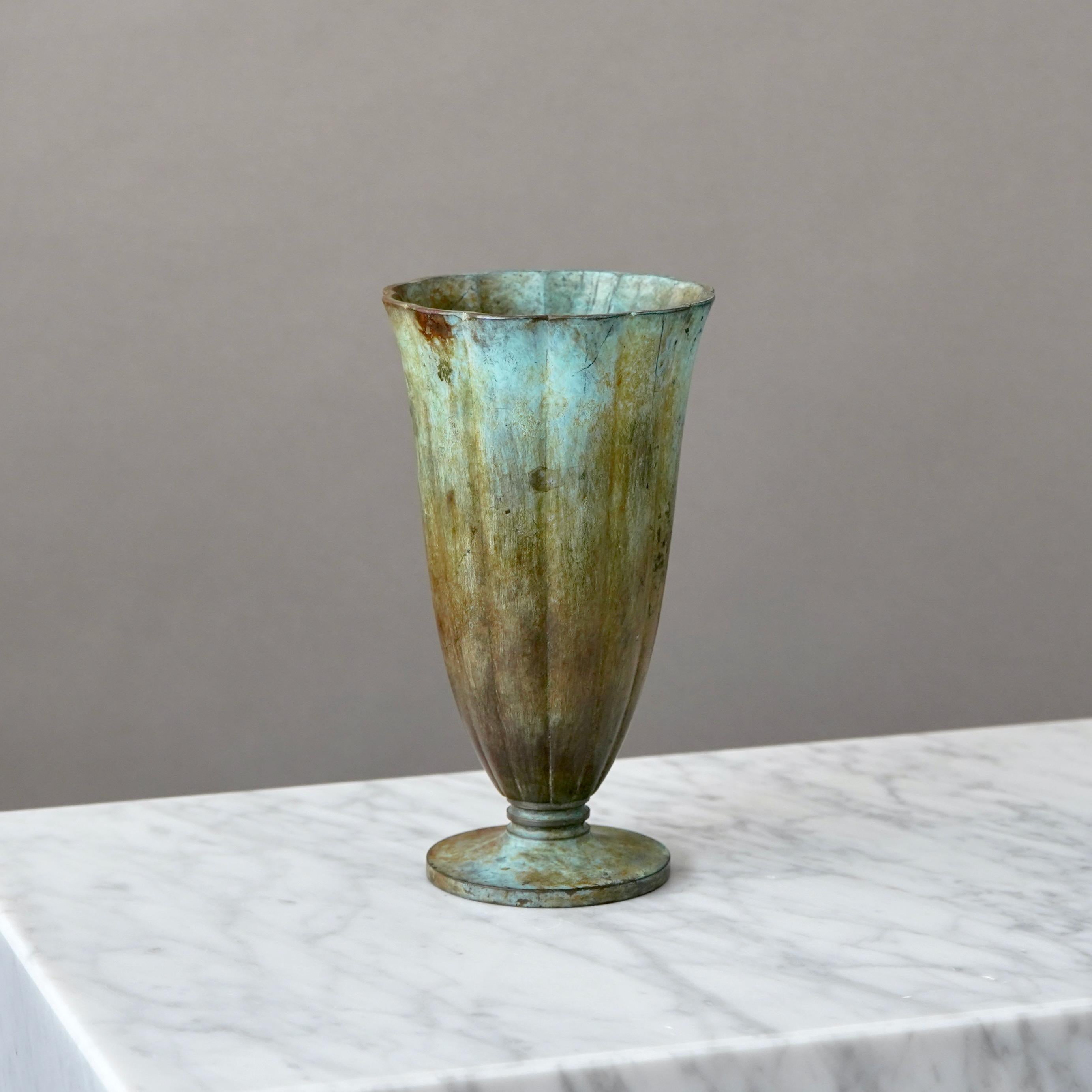 Un bellissimo vaso di bronzo con un'incredibile patina. 
Realizzata da GAB Guldsmedsaktiebolaget, Svezia, anni '30.  

Condizioni discrete. Graffi e usura della patina. Non trattiene l'acqua a causa di un piccolo foro.
Timbro 