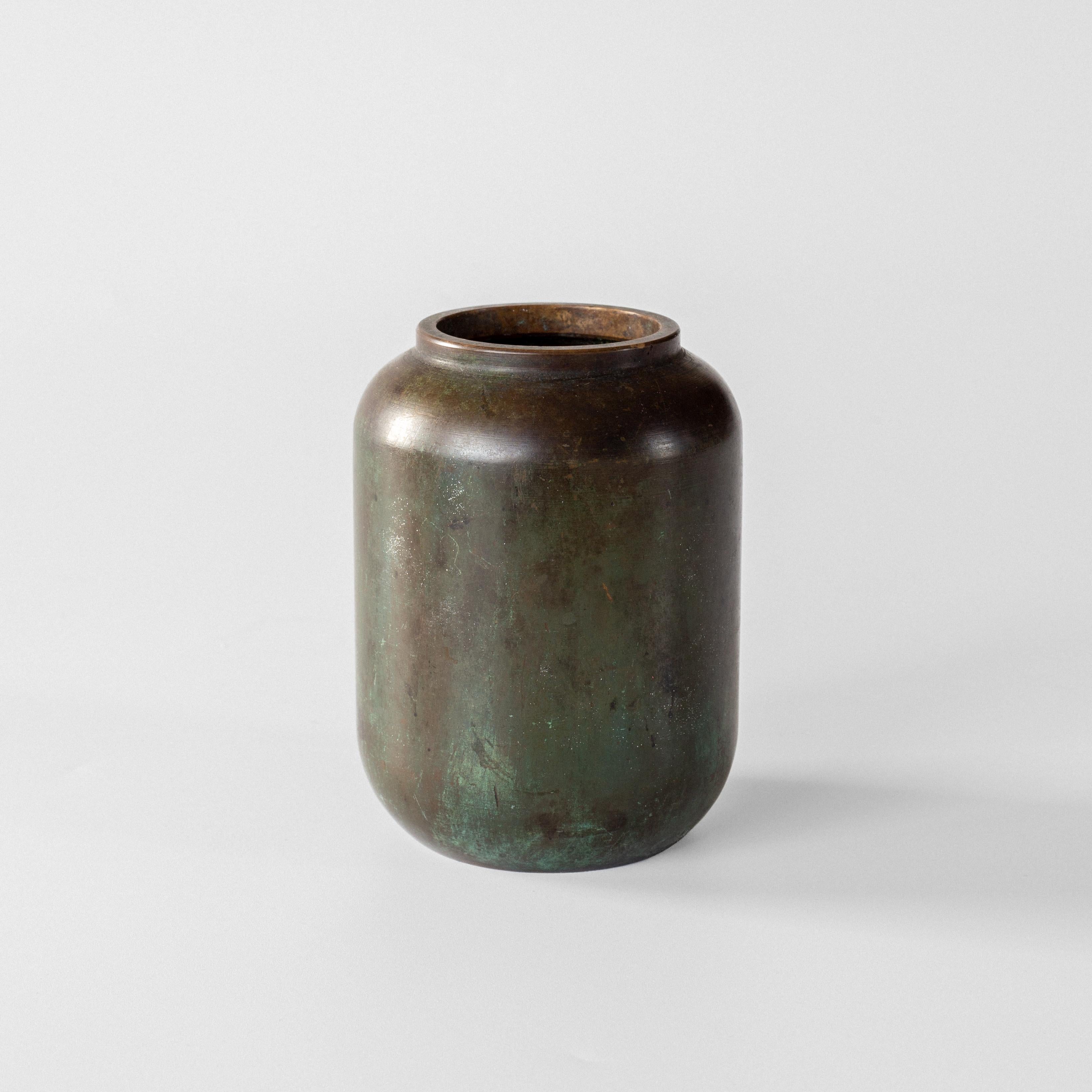 Questo elegante vaso in bronzo Art Déco è stato realizzato negli anni '30 da GAB (Guldsmedsaktiebolaget), rinomata azienda svedese di lavorazione dei metalli. Il pezzo presenta una silhouette da urna neoclassica con un'ampia base quadrata distintiva