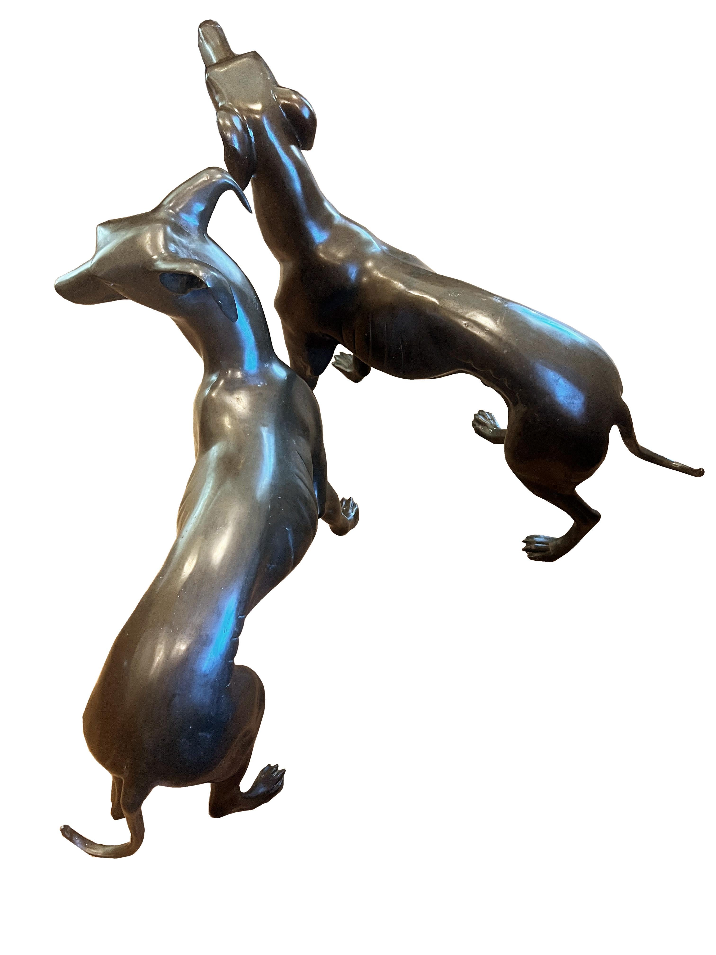 Introduce a touch of timeless elegance and distinguished style to your space with this handsome pair of life-sized Art Deco bronze whippets. These stunning sculptures perfectly encapsulate the glamour and sophistication of both the Mid Century and