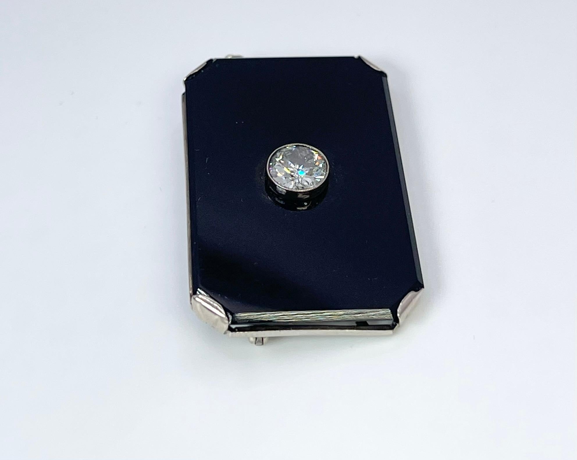 Seltene Art Deco Brosche mit einem großen Onyx und einem einzelnen Diamanten in der Mitte, der Diamant ist Old European cut. Das Jahr der Brosche ist unbekannt.

MITTELSTEIN: NATÜRLICHER DIAMANT
KARAT: 1.00CT
KLARHEIT: I2
FARBE: I
SCHNITT: RUNDE