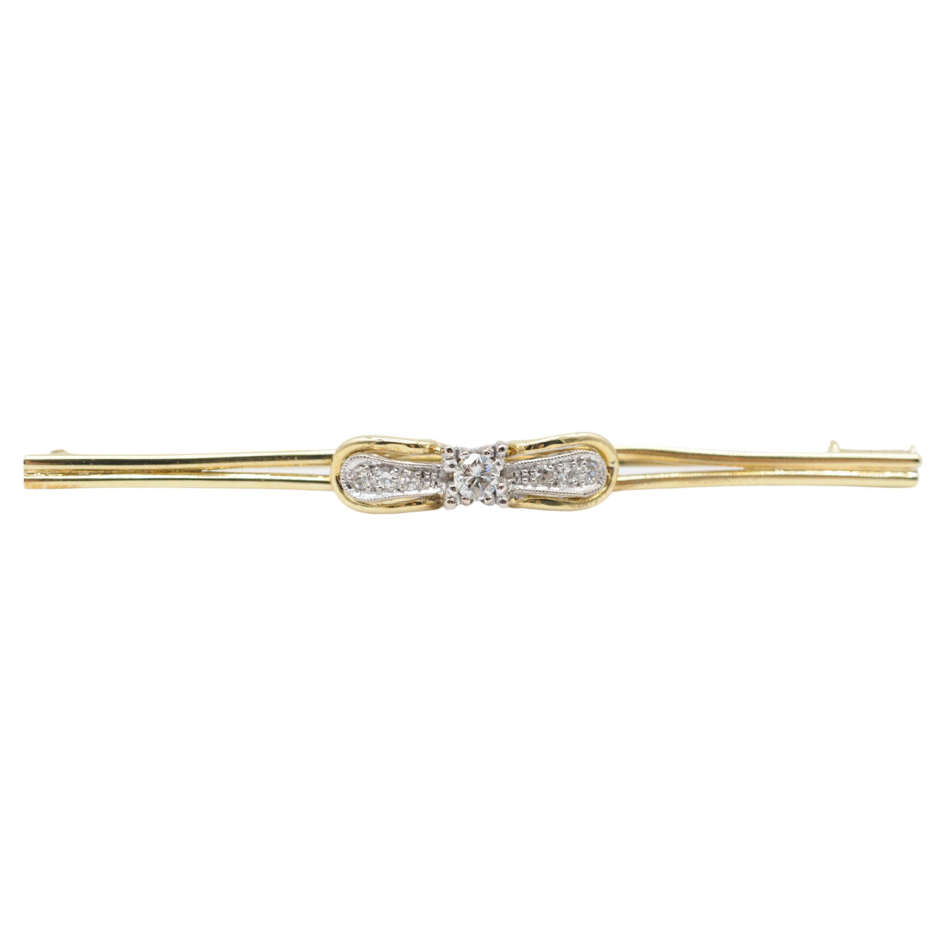 Indulge in the dreamlike charm of this exquisite 14k yellow gold Art Deco brooch—a true masterpiece of understated elegance. Crafted with meticulous attention to detail, this brooch features a total of seven diamonds, with a slightly larger diamond