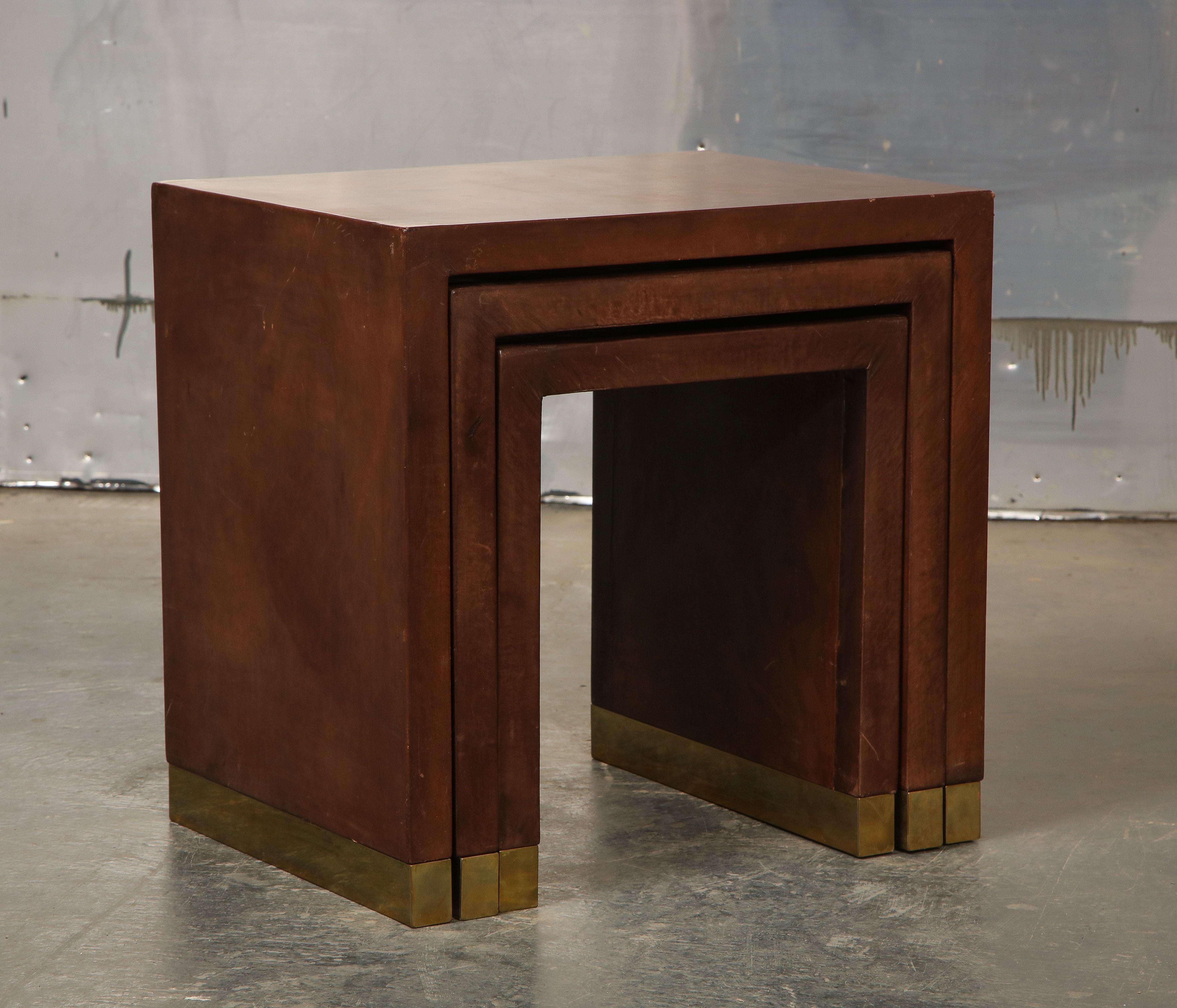 Each graduated table wrapped in buttery fine-grained brown leather with beautiful patina with brass-trimmed feet.