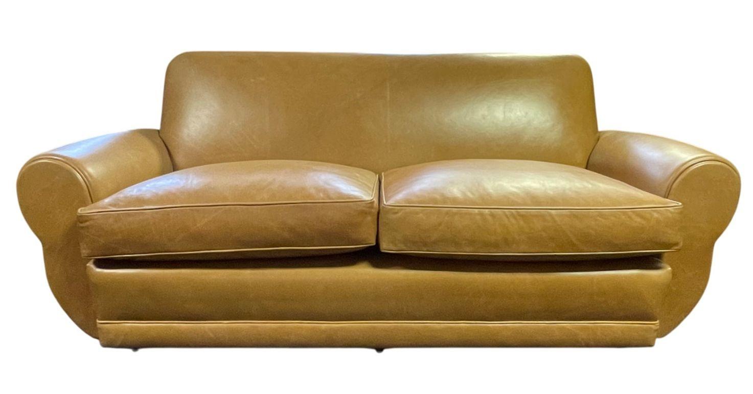 A striking Art Deco sofa from the 1940's, crafted in the USA and newly upholstered in a warm light brown leather. The sofa features classic Art Deco design elements, including clean lines, subtle curves, and a sturdy silhouette that balances