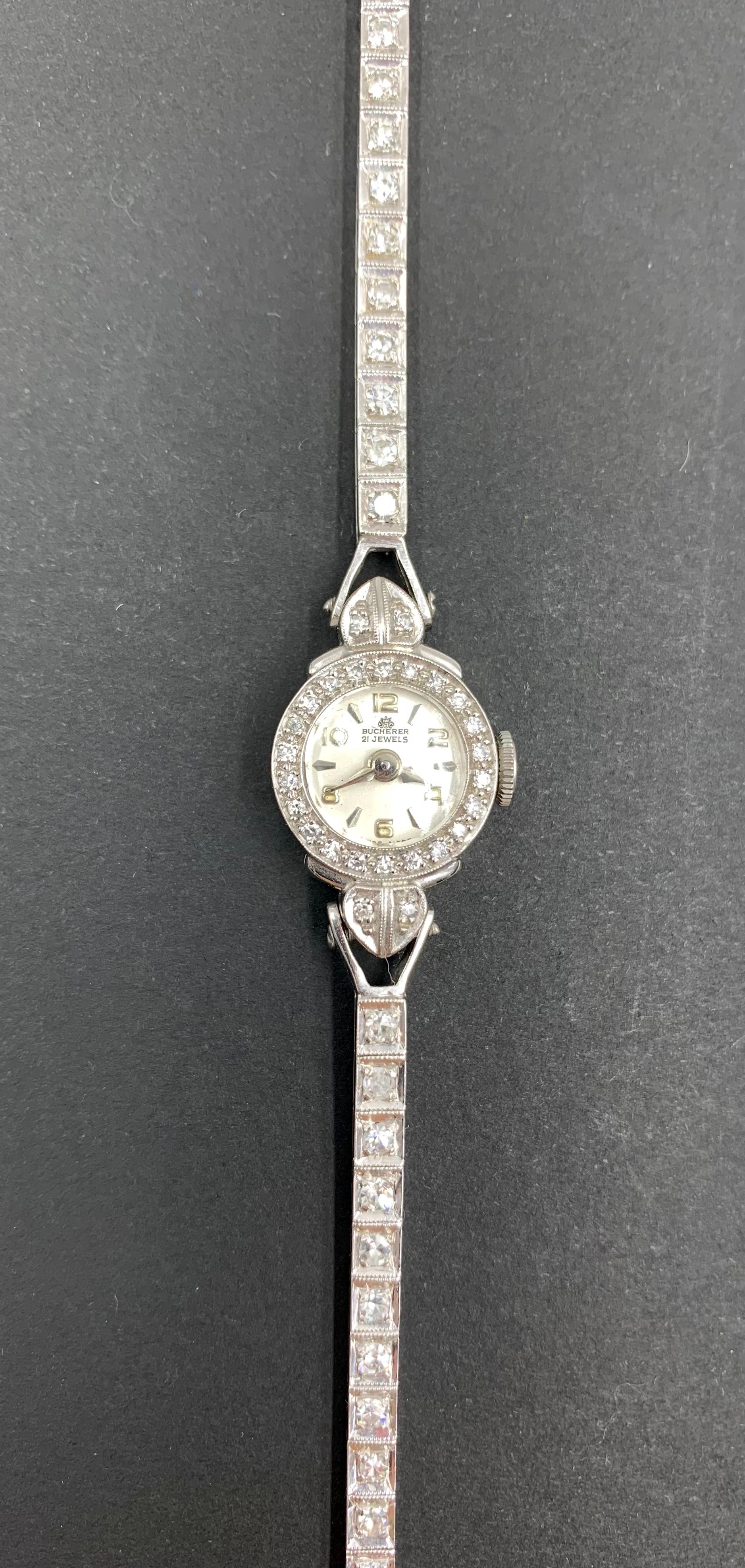 Elegante Art Deco Periode Bucherer Diamant, Platin, 14K Weißgold Armbanduhr von zierlicher Form.
Anfang des 20. Jahrhunderts
Mini-Uhren haben im Laufe der Jahre einige fabelhafte Handgelenke geziert - Königin Elisabeth II. trug eine zu ihrer