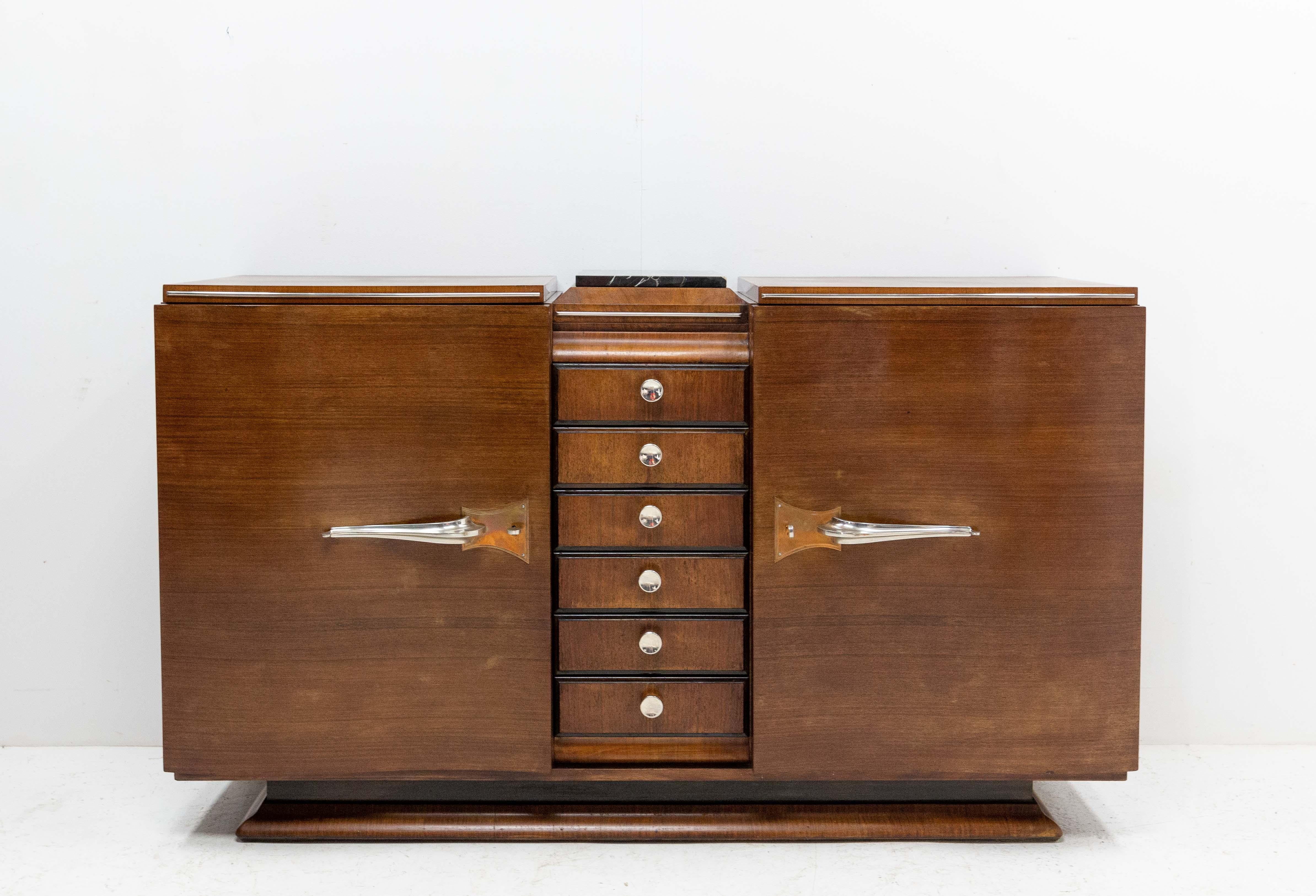 Cabinet Art Deco, French, circa 1930.
Credenza buffet walnut and marble with chrome brass chopsticks.
Two doors and six drawers.
The buffet has been made in three parts. The top of the center part is recovered of black marble.
The top drawer is